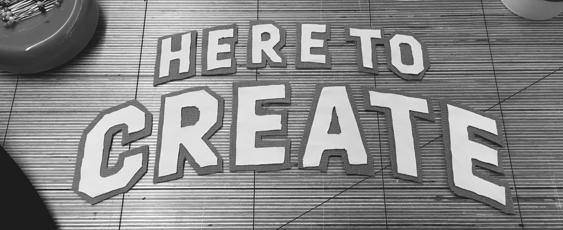 Photograph of cut out letters that read "Here to Create."
