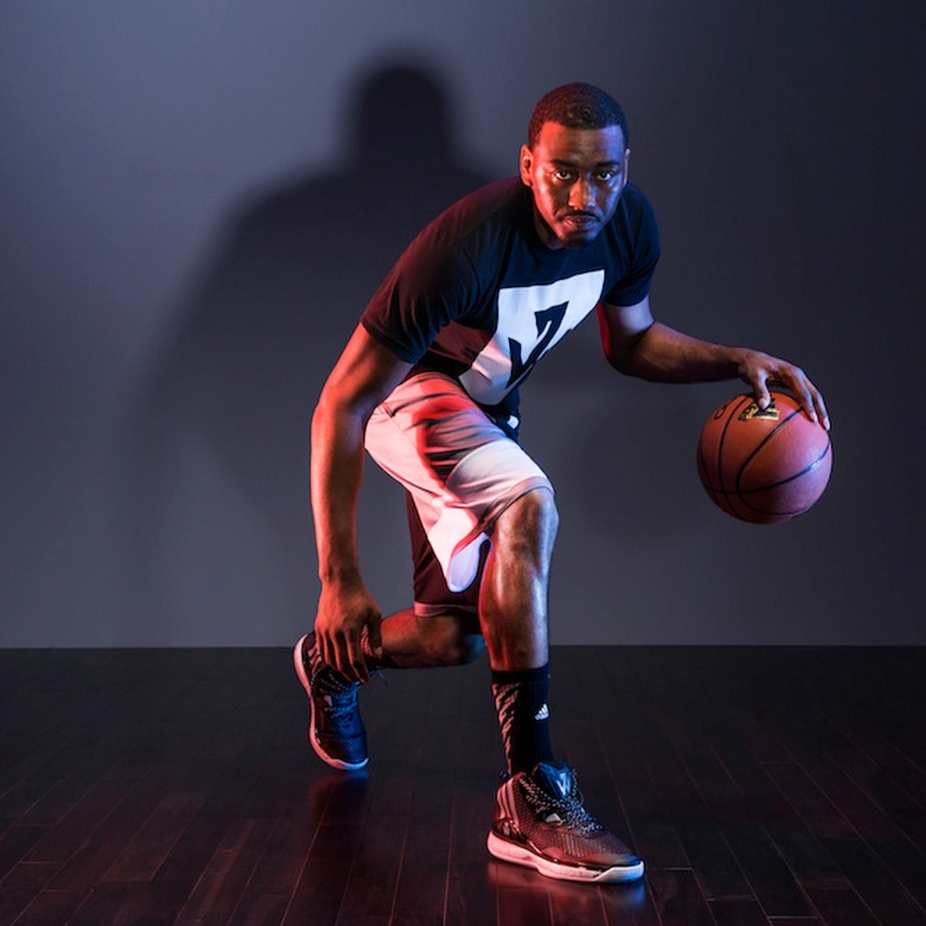 Photograph of John Wall dribbling while wearing logo t-shirt.