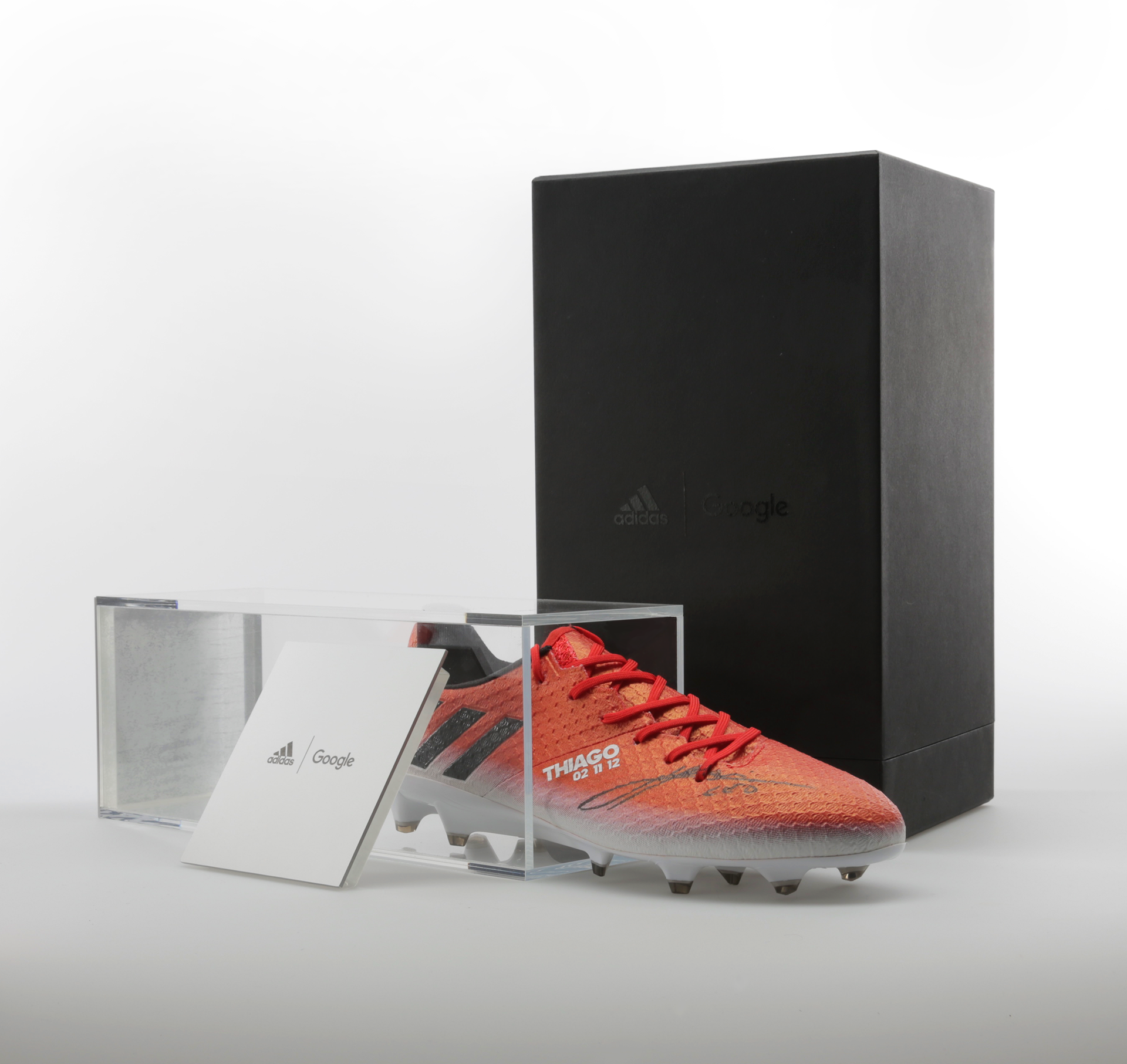 Photography of final display box open, with shoe out and engraved end-caps propped against acrylic shoe housing.