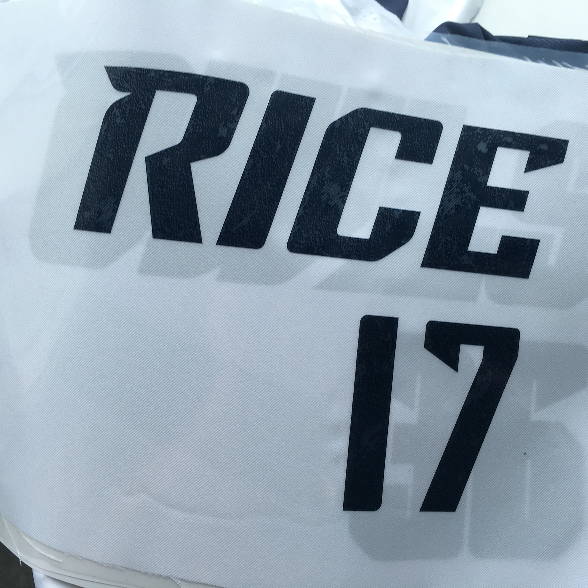 Photograph of "Rice" wordmark and "17" numerals on a heat transfer sheet prior to transferring to garment.