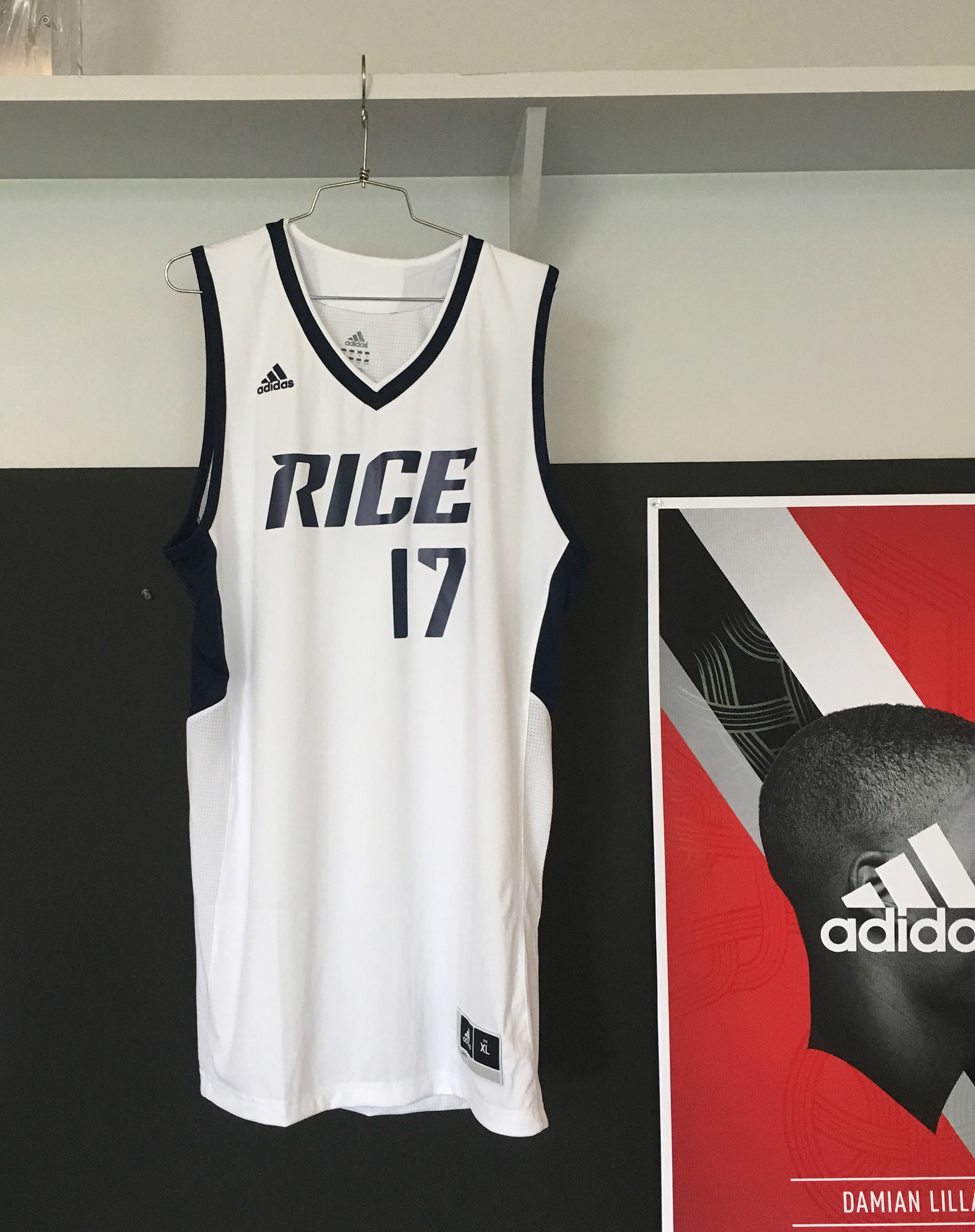 Photograph of basketball jersey hanging up in the office utilizing new wordmark and number system.