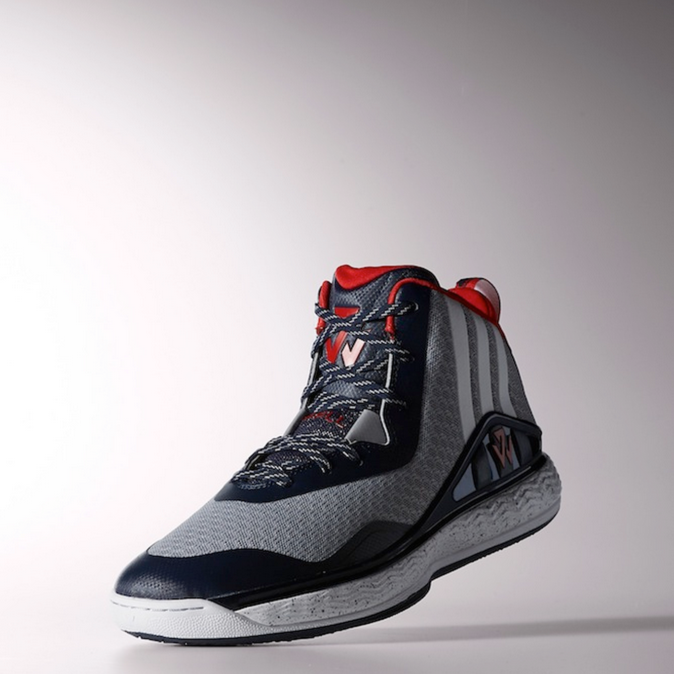 Photograph of three-quarter view of J-Wall 1 shoe in red, gray and navy toting the new logo.