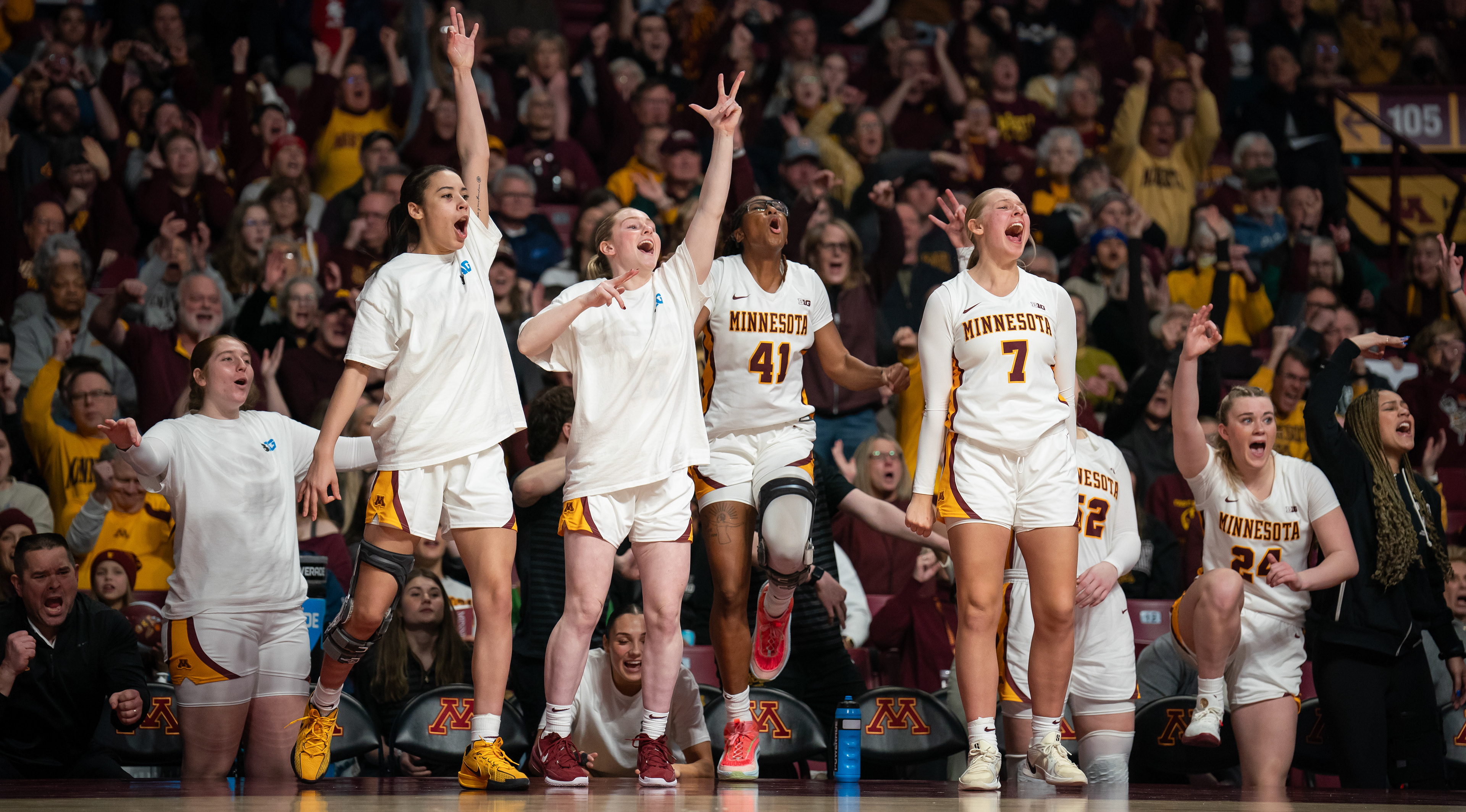 Kennedy Klick, Brynn Senden, Niamaya Holloway and Makenna Johnson all celebrate a three-point shot on the court during a game against the University of Michigan in Minneapolis, Minn.