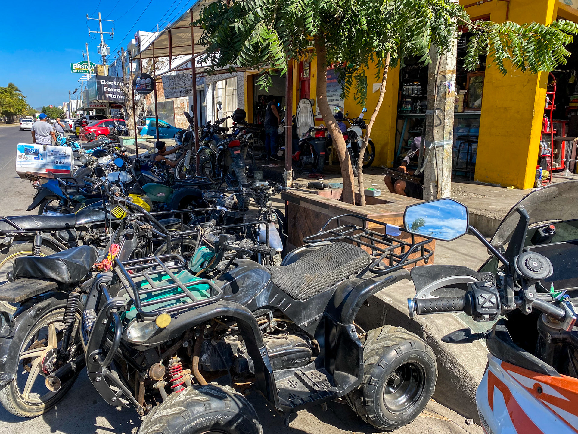 We ride a few blocks away to another shop with the bandwidth to mount it. Look at the guy just above my mirror re-spoking a wheel.