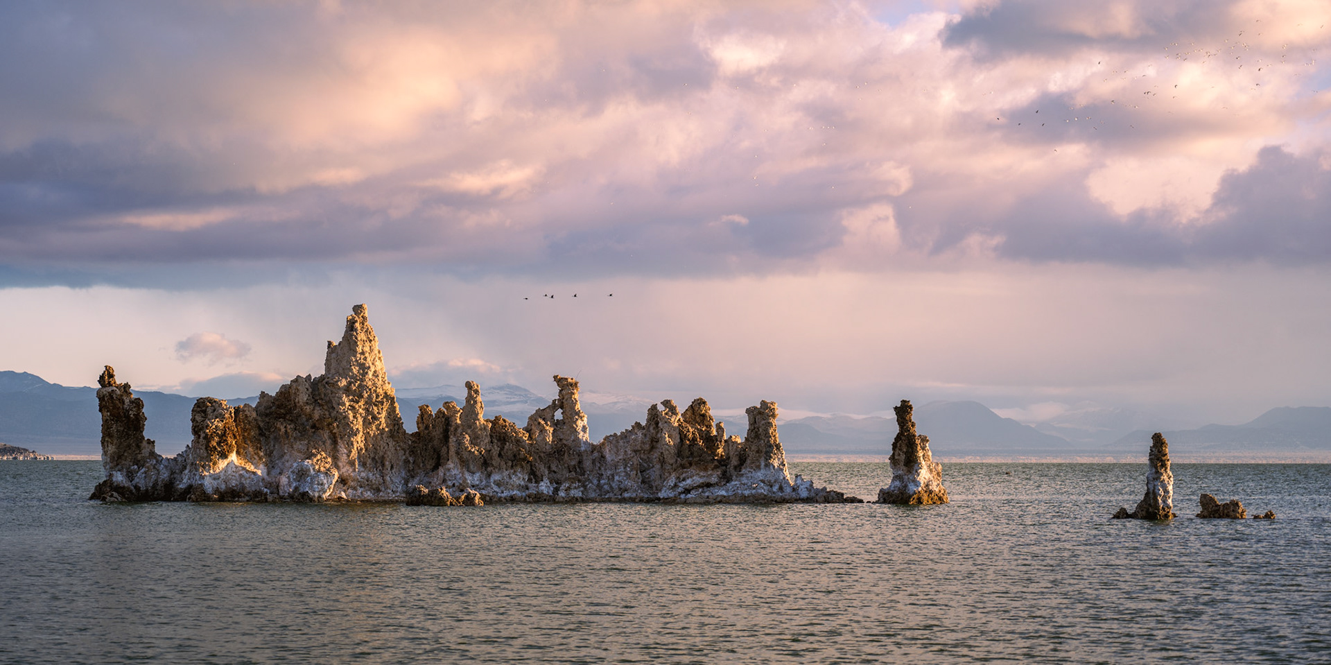 Geese migrating just above the tufa, while other birds fly up in the top right corner