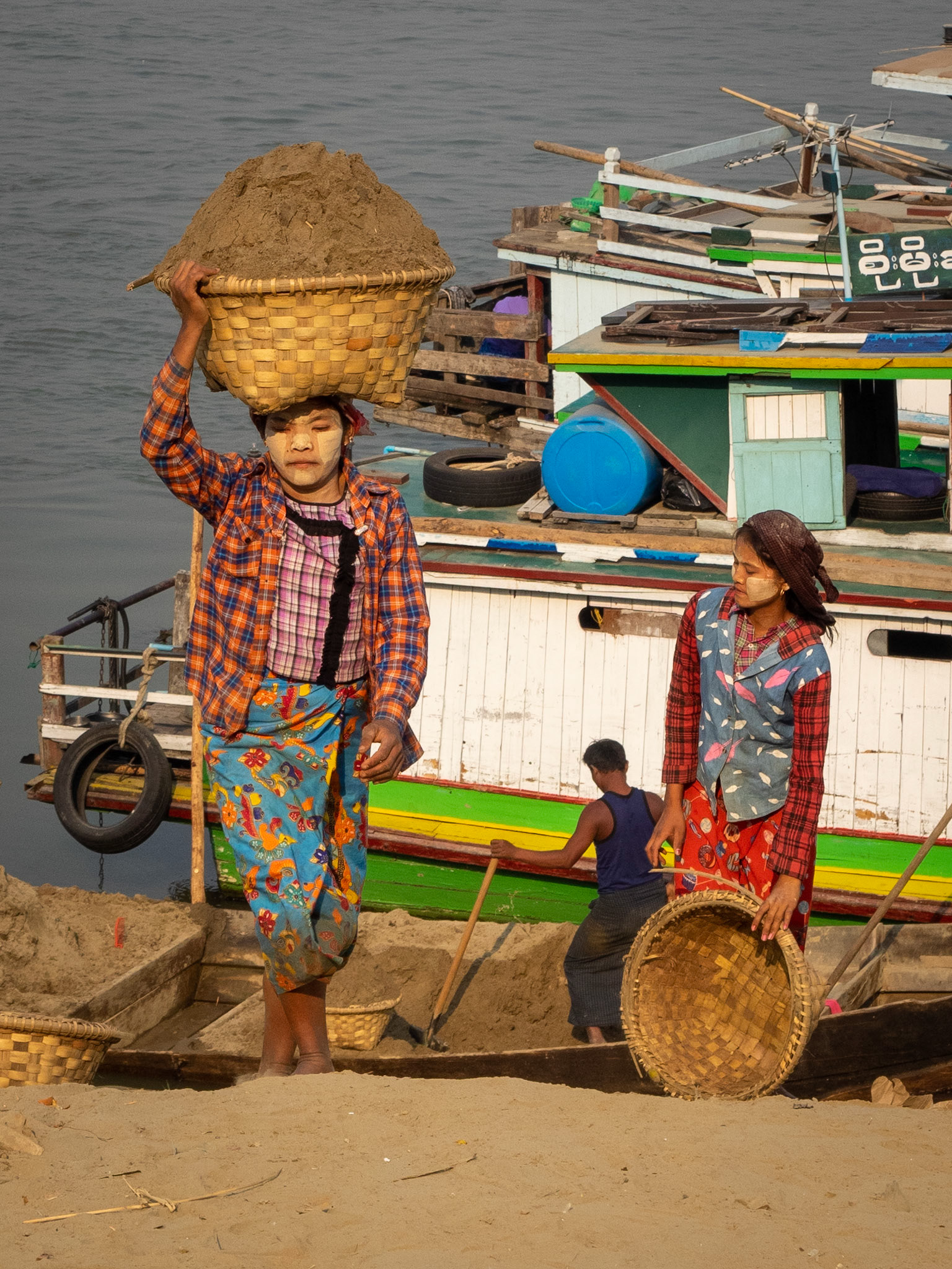 This is fine sand for concrete that these women are carrying from the boat, high up to the bank. It must weight a ton!