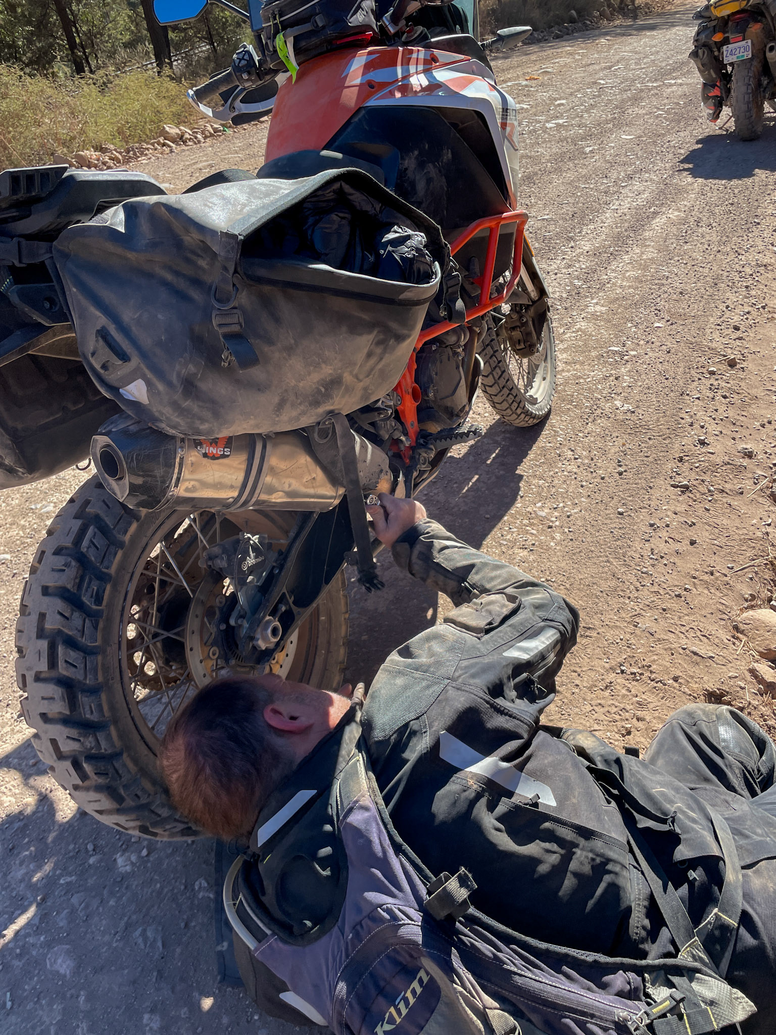 At some point I got blinded by such a wall of dust and ended up dumping my motorcycle resulting in a dislocated exhaust tailpipe. Here I am fixing the pipe and we’re on our way again.