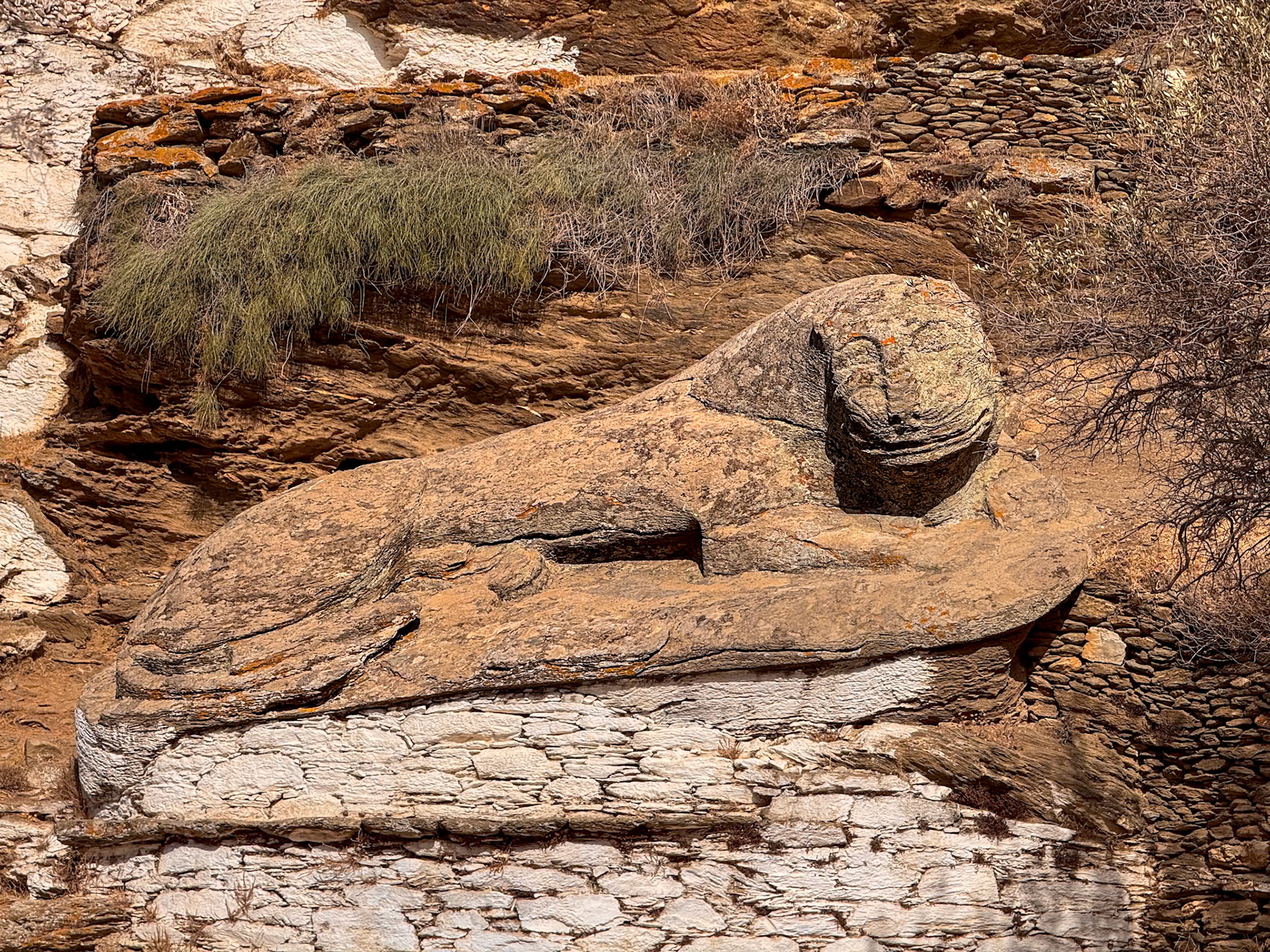 The Lion of Kea, one of the island’s most famous landmarks. The stone sculpture, believed to date back to the 6th century BC, is about 6 meters long and represents a reclining lion with a serene and slightly smiling expression, typical of ancient Greek archaic art.