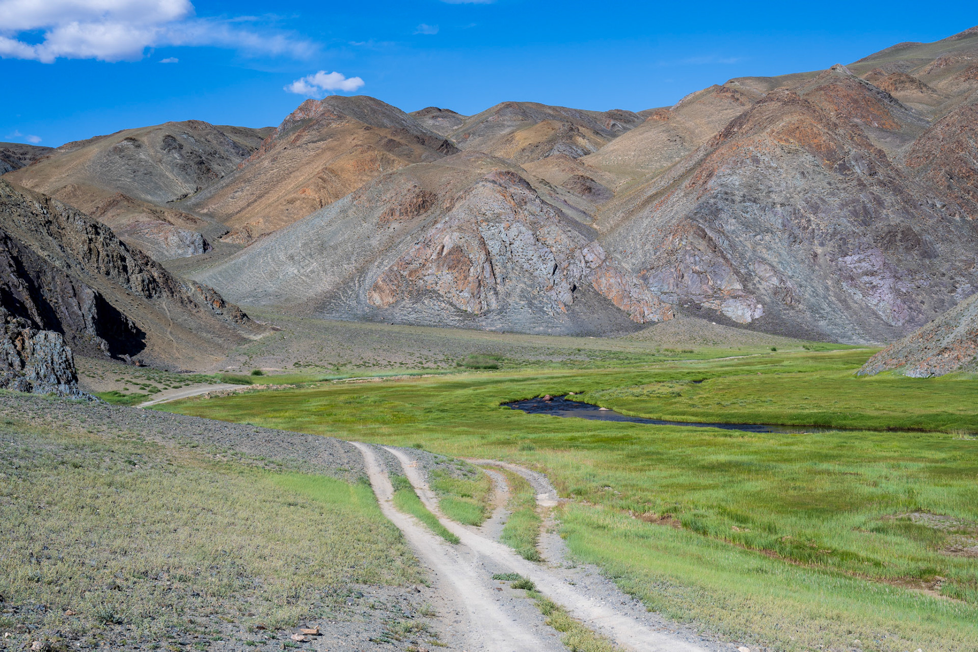 Death Valley style mountains but with a lush river