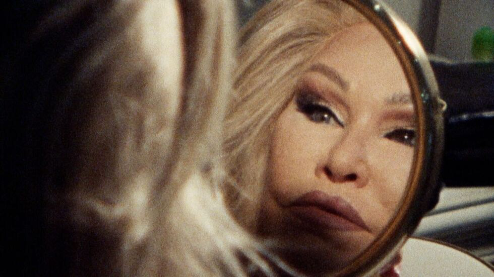 New York Socialite Jocelyne Wildenstein aka the "Catwoman" looks at herself in a handheld mirror in Super 8 style footage.
