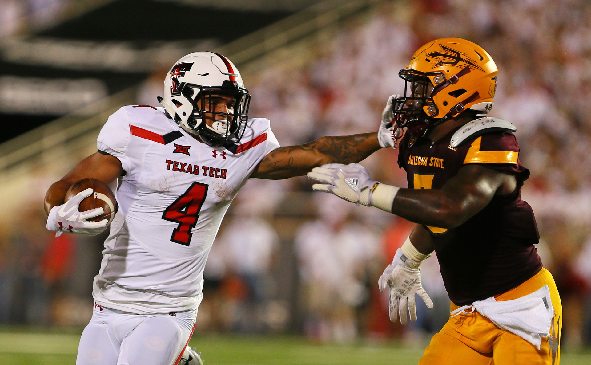 LUBBOCK, TX - SEPTEMBER 16: Texas Tech running back Justin Stockton (4) stiffarms a defender during the Texas Tech Raider's 52-45 victory over the Arizona State Sun Devils on September 16, 2017 at Jones AT&amp;T Stadium in Lubbock, TX. (Photo by Sam Grenadier/Icon Sportswire)