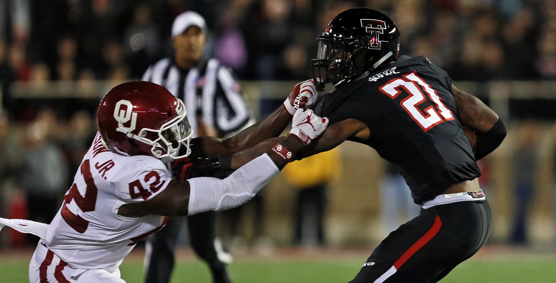 Texas Tech's Da'leon Ward (21) stiffarms Oklahoma's Mark Jackson Jr.(42) during the game against Oklahoma Saturday, Nov. 3, 2018, at Jones AT&amp;T Stadium in Lubbock, Texas. [Sam Grenadier/A-J Media]