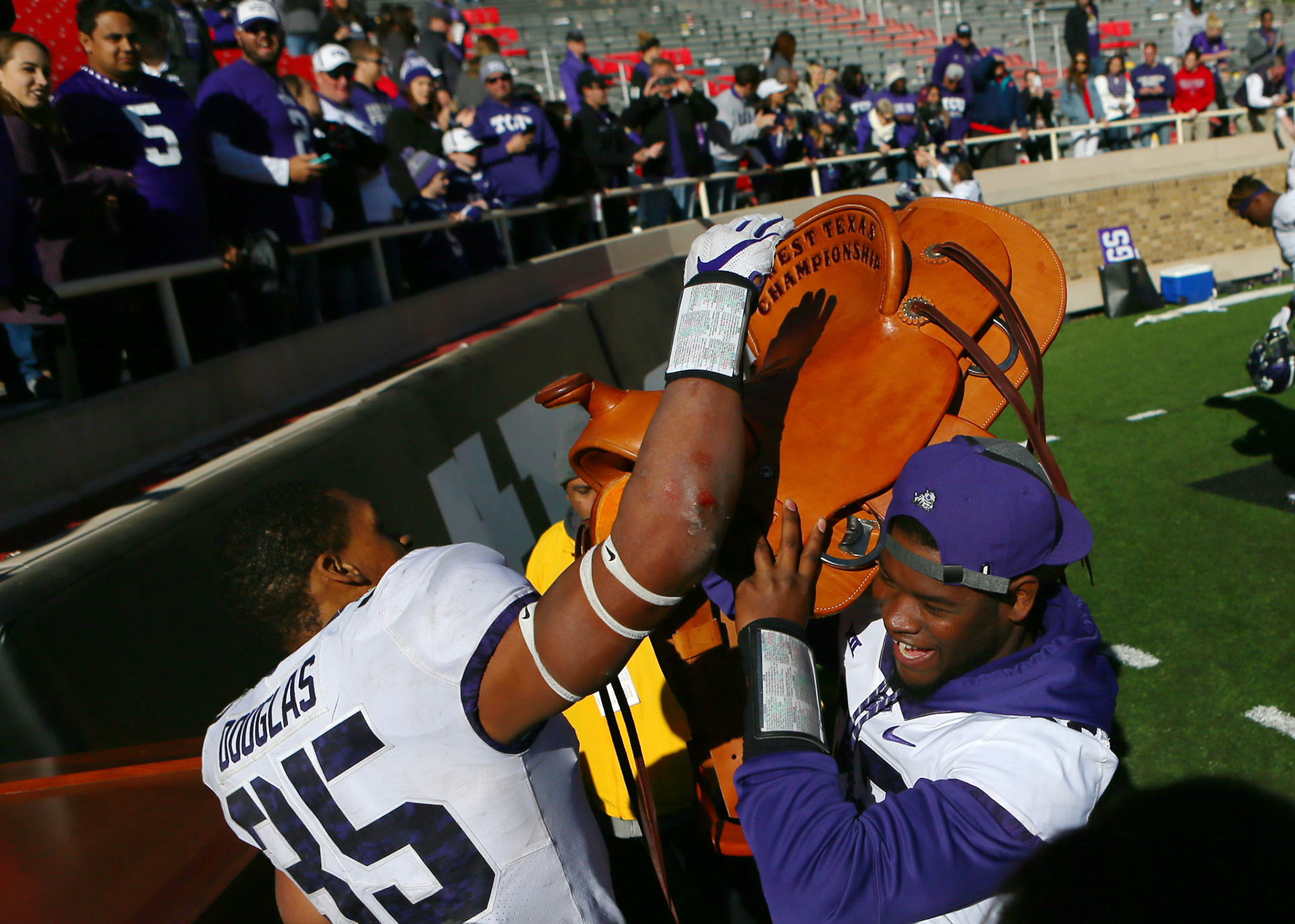 LUBBOCK, TX - NOVEMBER 18: Texas Christian linebackers Travin Howard (32) and Sammy Douglas (35) lift the West Texas Championship Saddle in victory after the Texas Tech Raider's 27-3 loss to the Texas Christian University Horned Frogs on November 18, 2017 at Jones AT&amp;T Stadium in Lubbock, TX. (Photo by Sam Grenadier/Icon Sportswire)