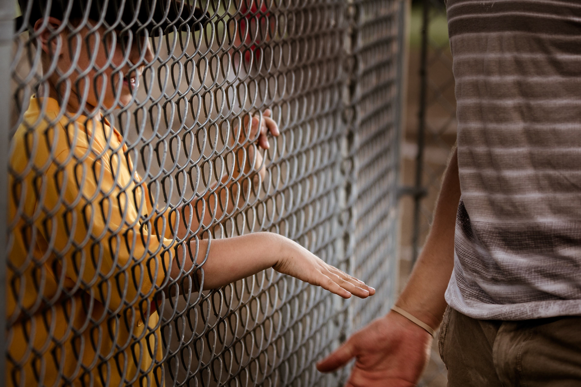 Hands through the fence
