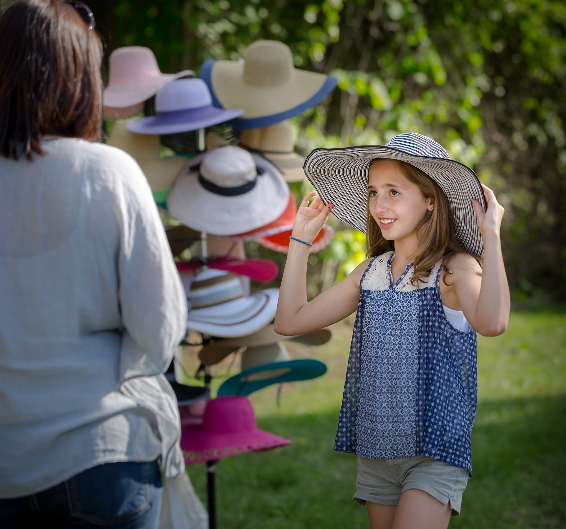 Young girl tries on a hat at the annual Keswick Horse Show