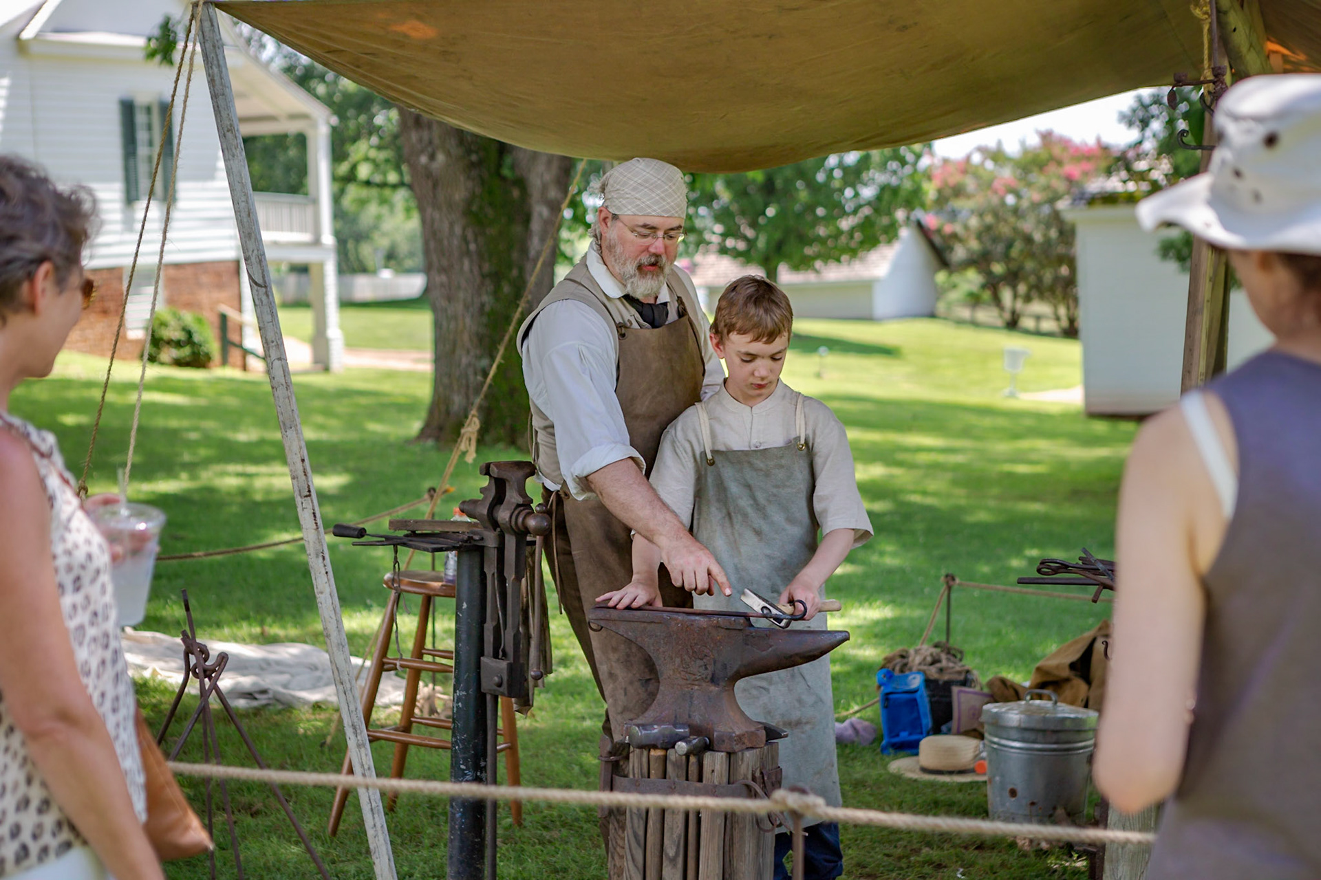 Father and son demonstrating blacksmithing