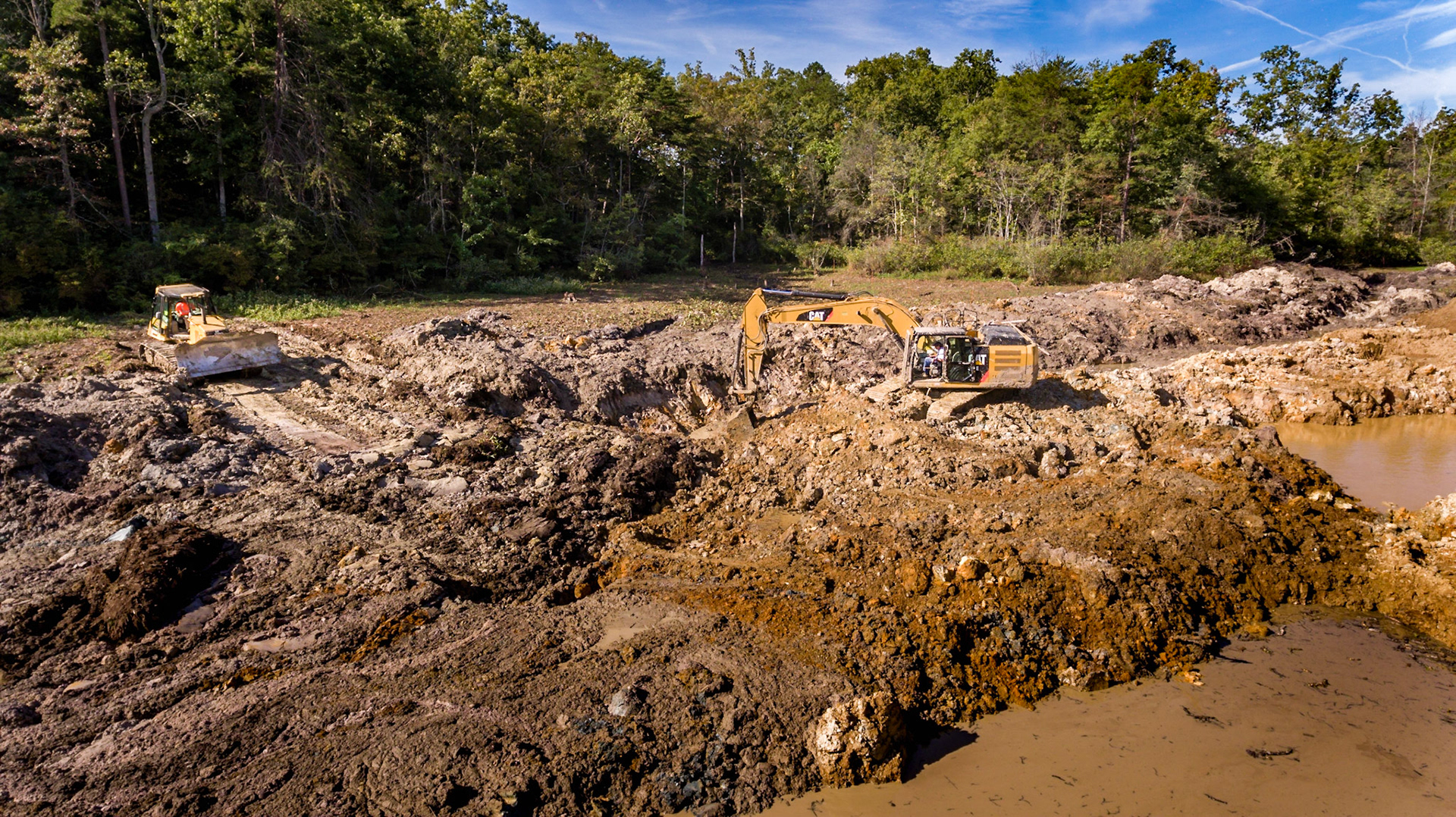 Pushing muck and lily pads into pit