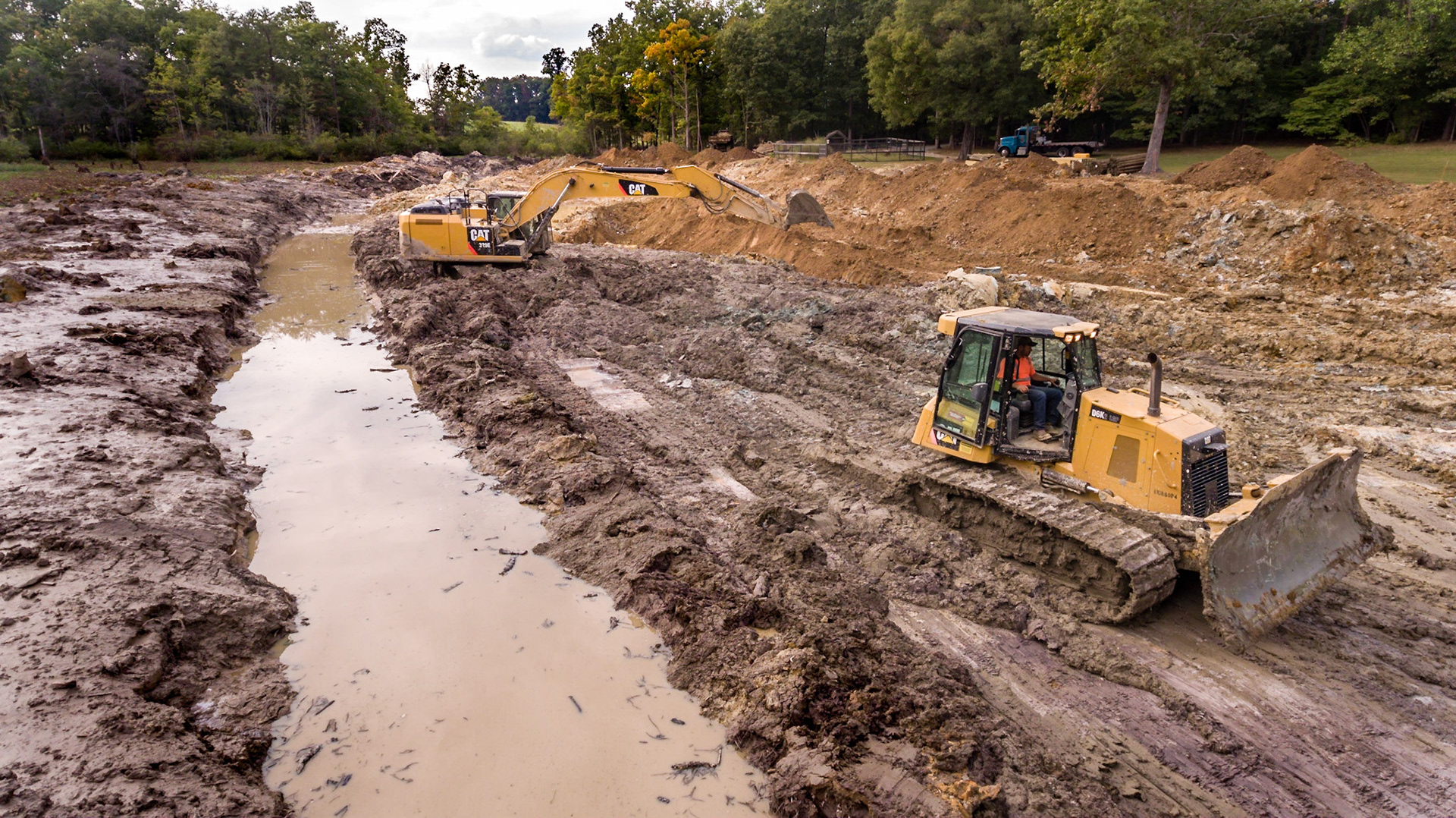 The CATs rounding up muck and lily pads to put in a hole that good dirt was harvested from.