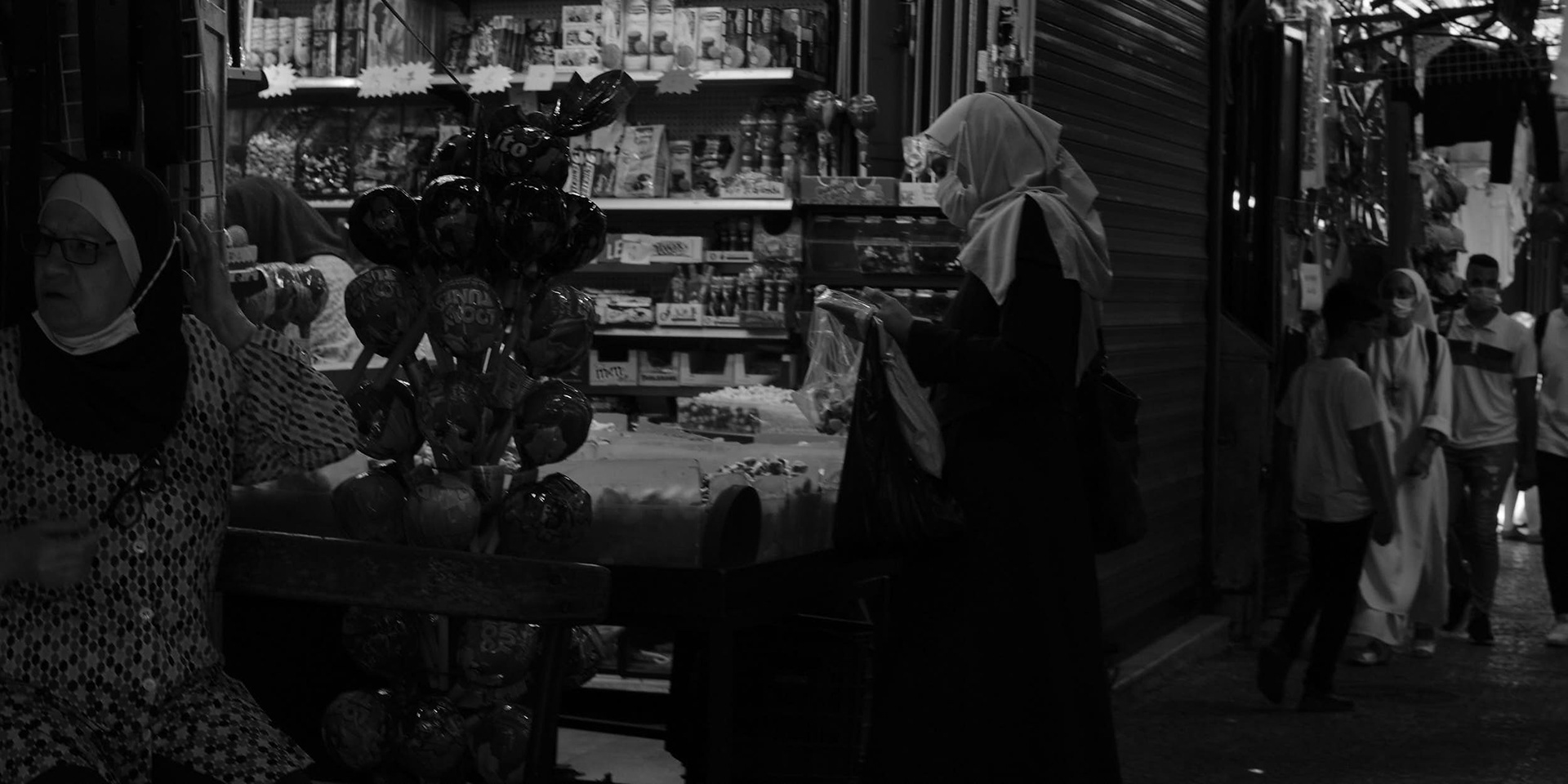 A Palestinian woman is investigating the offerings of one of the shops.
