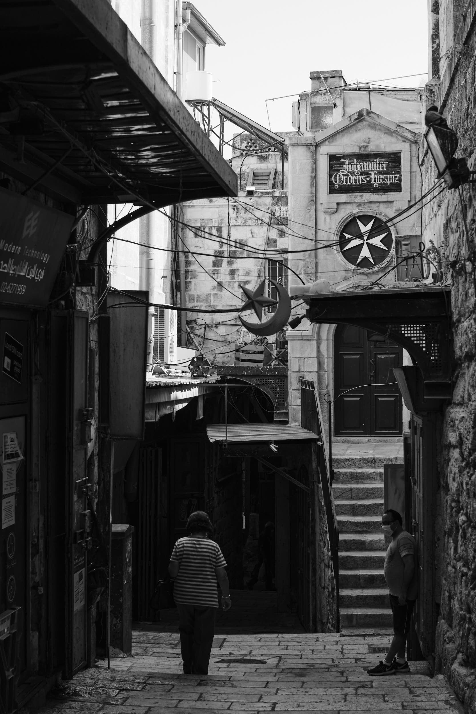 Entering the Muslim Quarter from the Christian Quarter, symbolized by a Christian cross and a Muslim half moon.