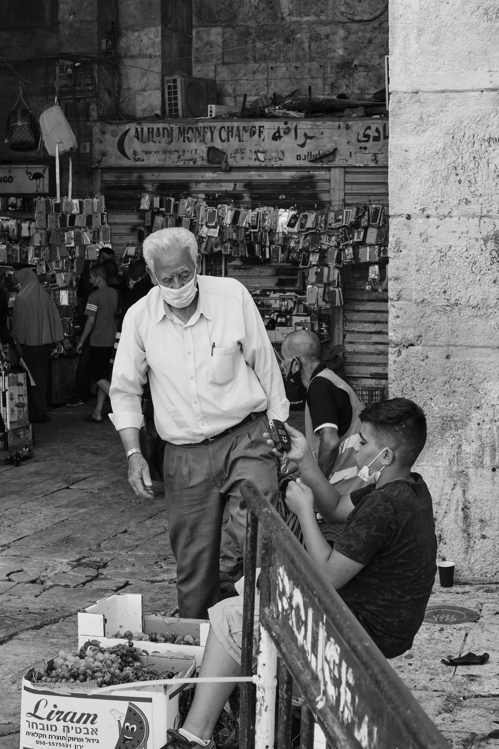 An old Palestinian man greets a boy selling his products at the entrance to the Damascus Gate of the Old City of Jerusalem.