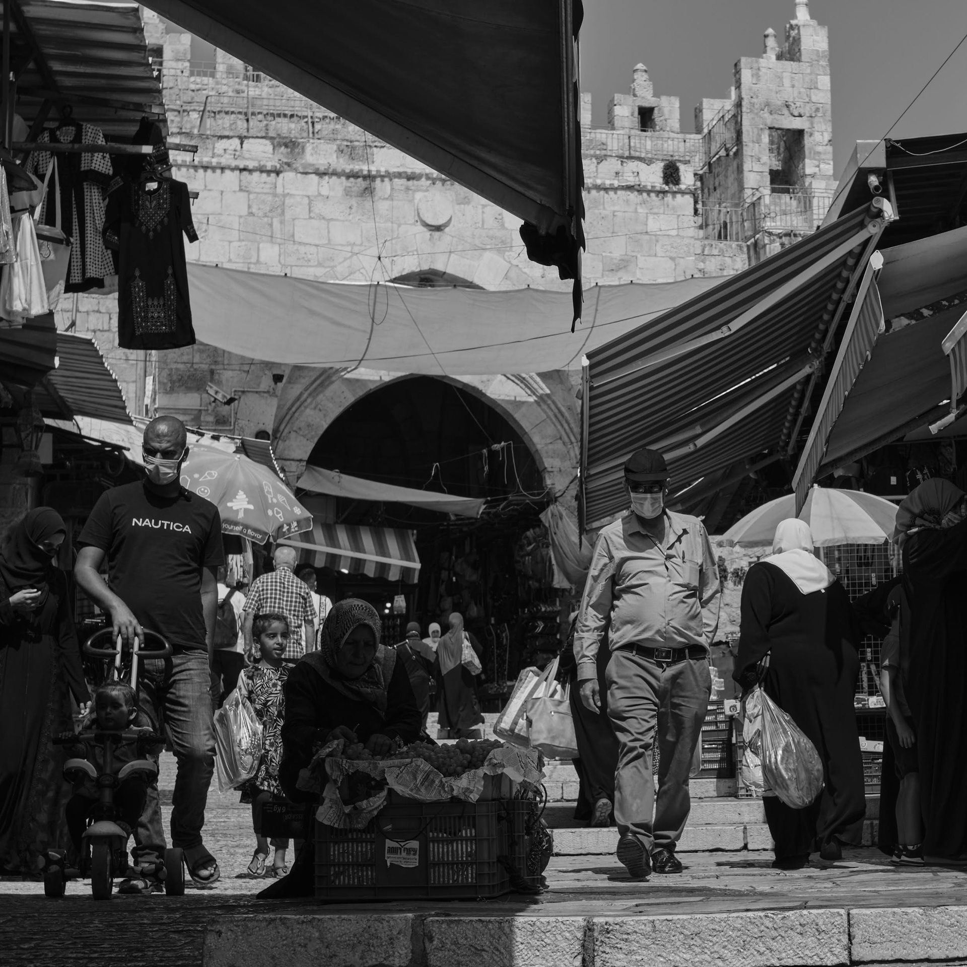 The Damascus Gate appears in the background of the busy Al-Wad Street.