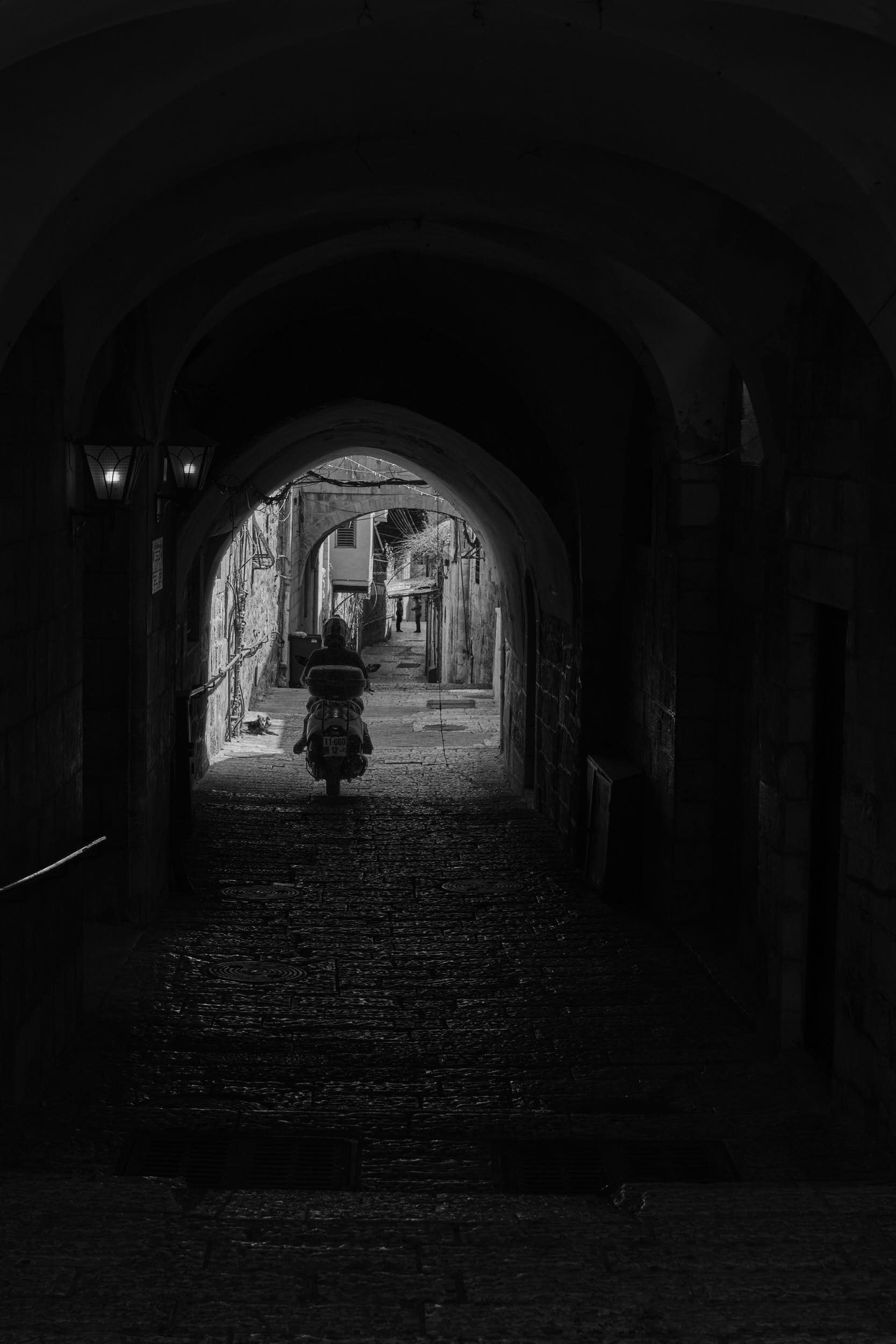 A scooter racing through one of the covered parts of the streets in the Christian Quarter of the Old City of Jerusalem.