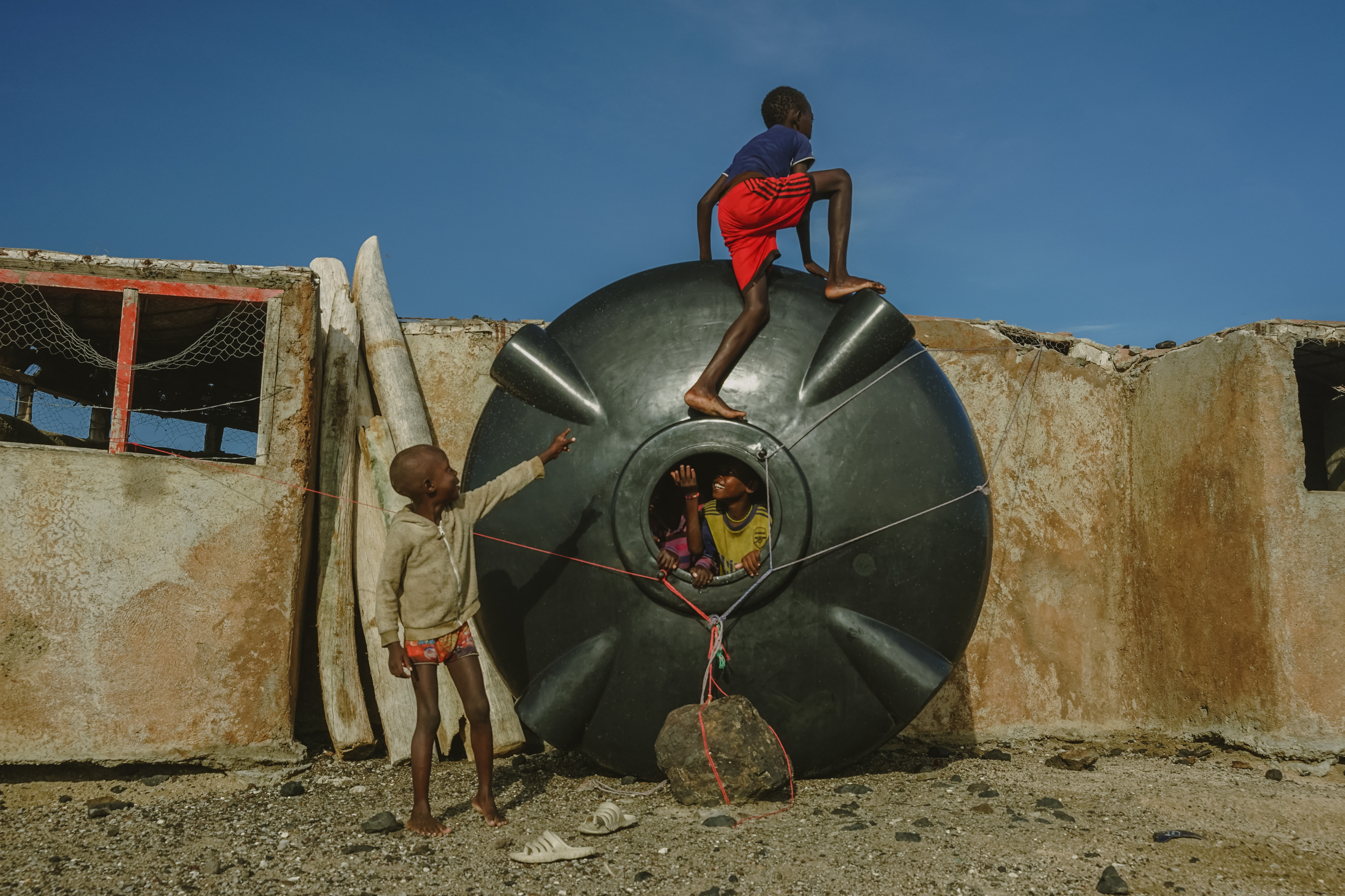 Kids on Komote Island play on a disused water tank given by an NGO. Meant to collect rainwater in an area where it rains on average once every four years, it is now used for parts.