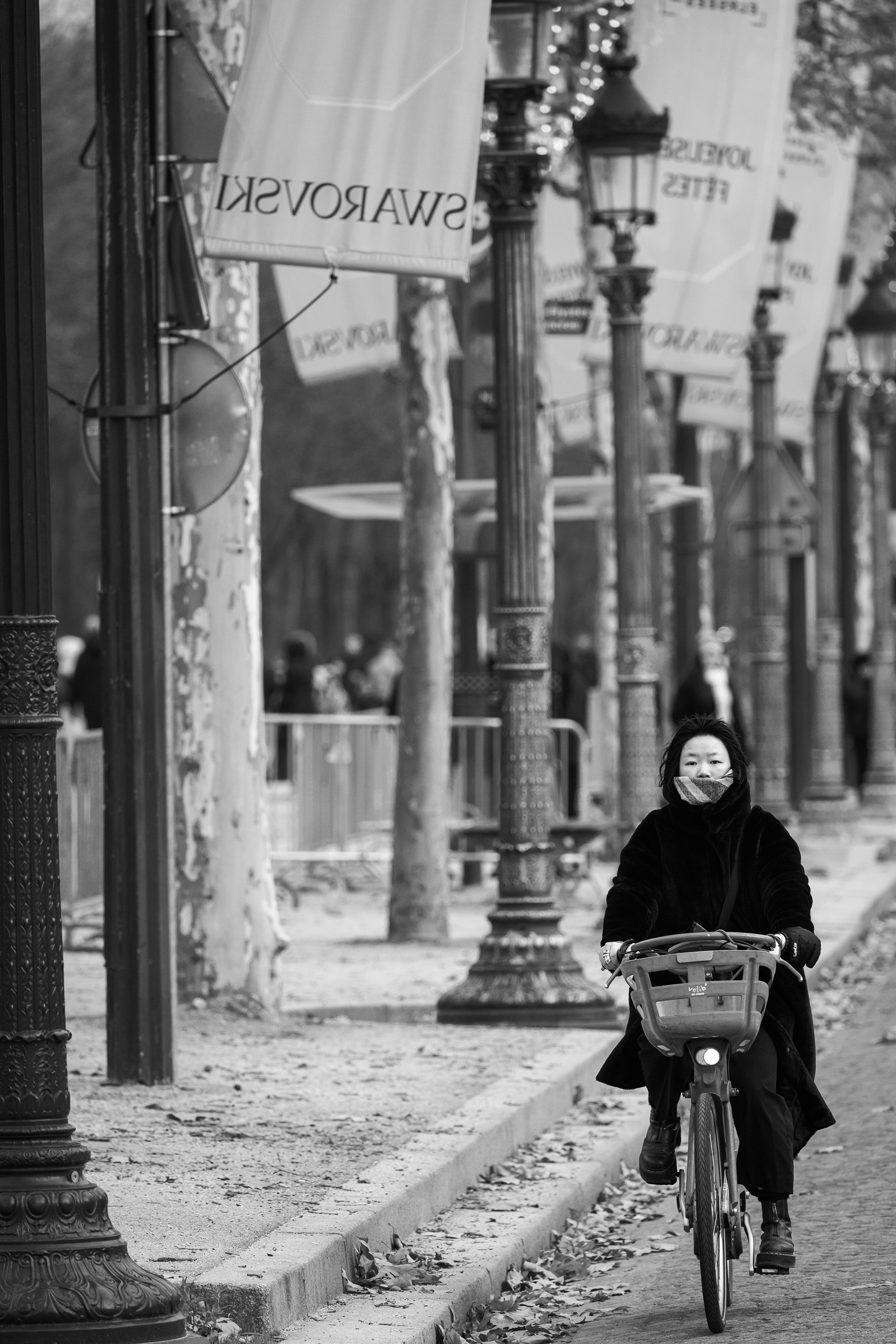 Cycling up the Champs-Élysées in the winter cold. Featured by Monomoods.