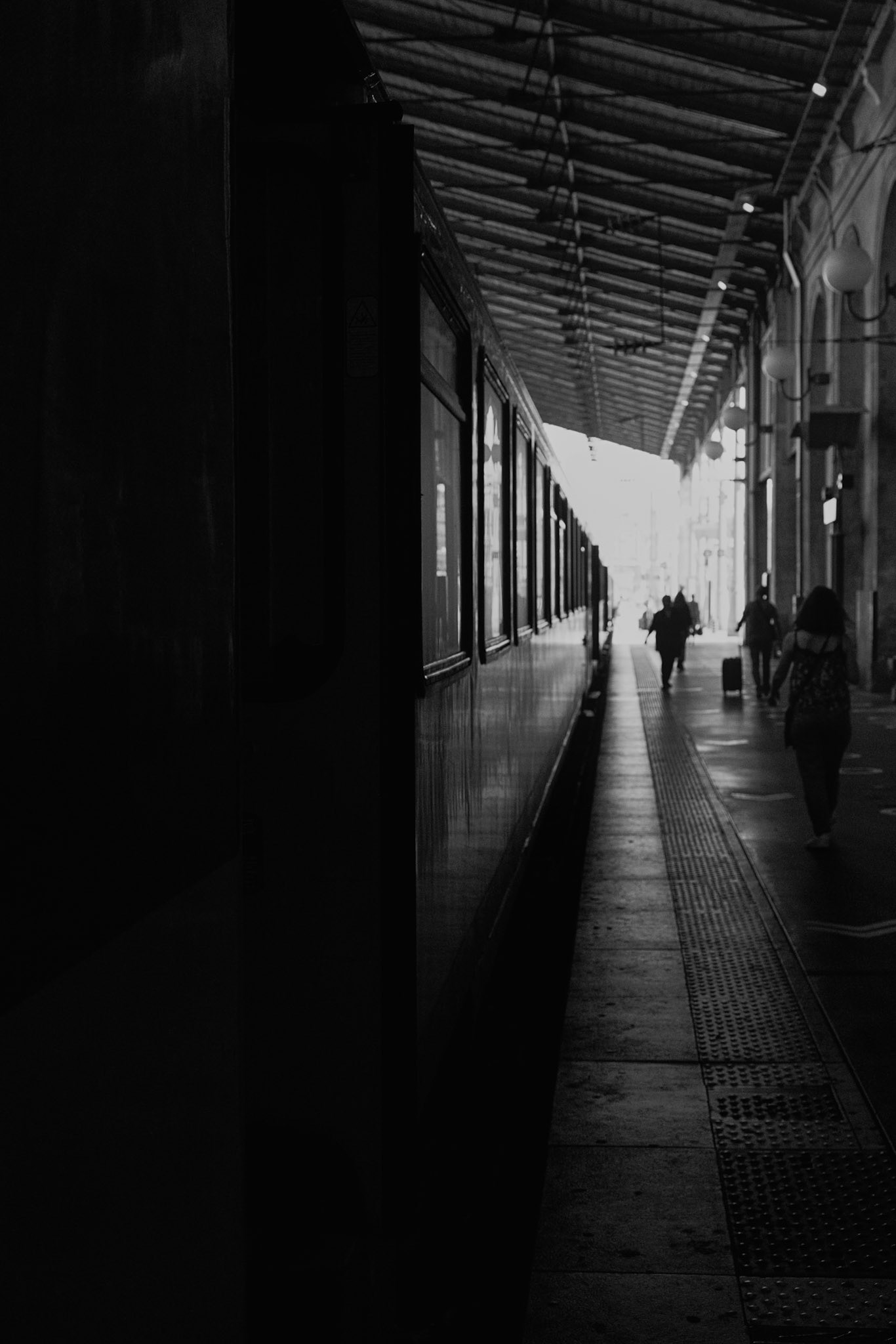Gare du Nord, Paris. Several figures moving through the dark platform toward the light.