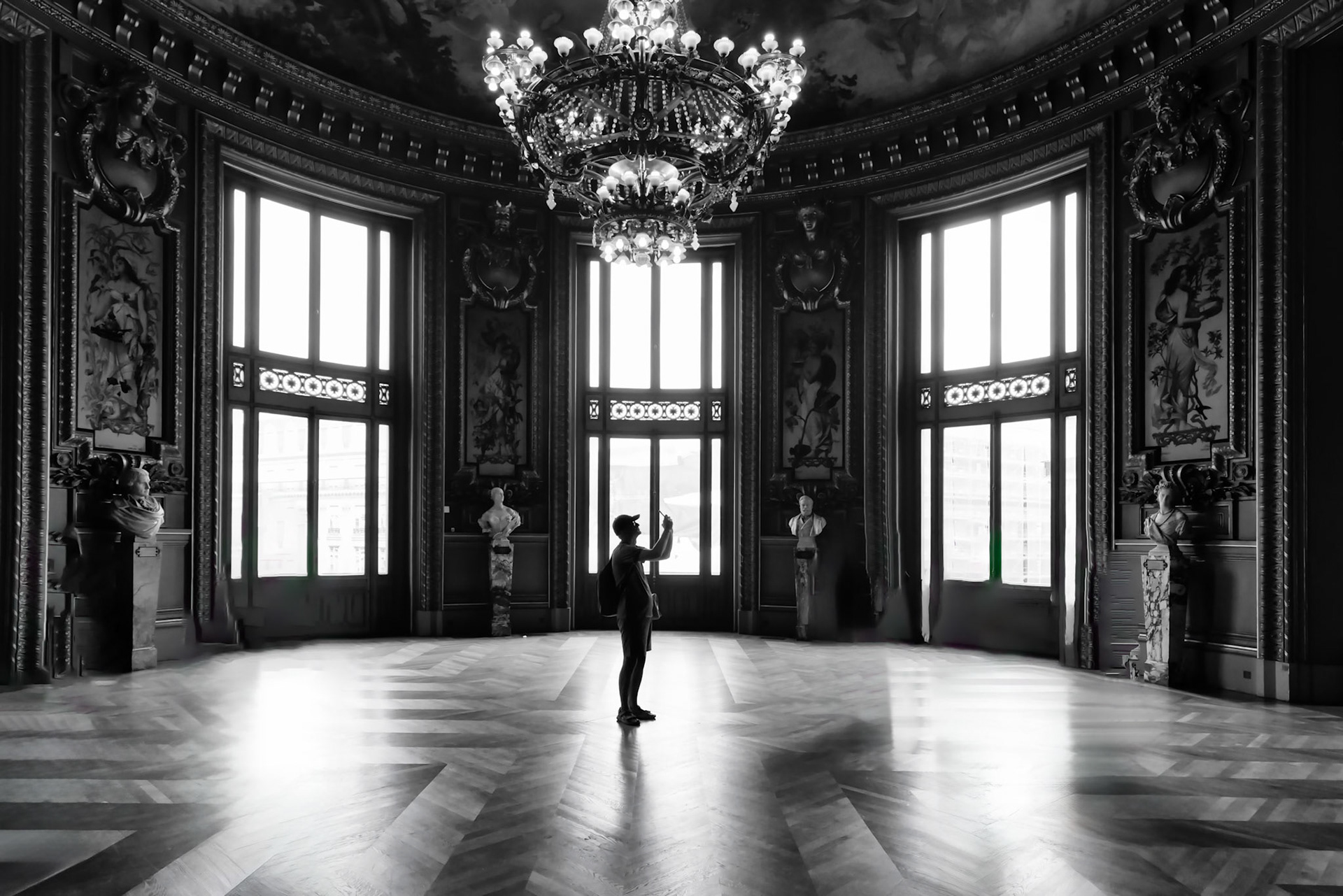 A solitary figure in the grand salon of the Palais Garnier