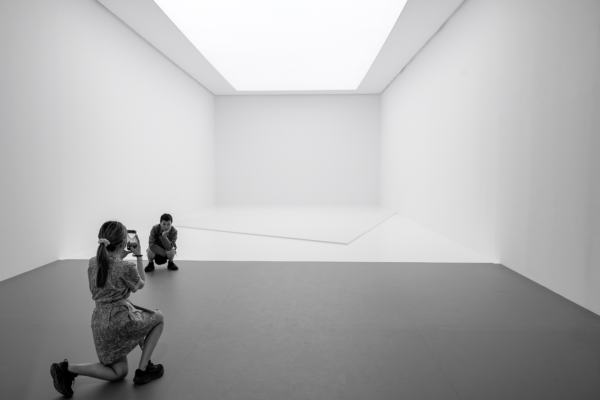 Two visitors photographing inside a white gallery at the Fondation Louis Vuitton