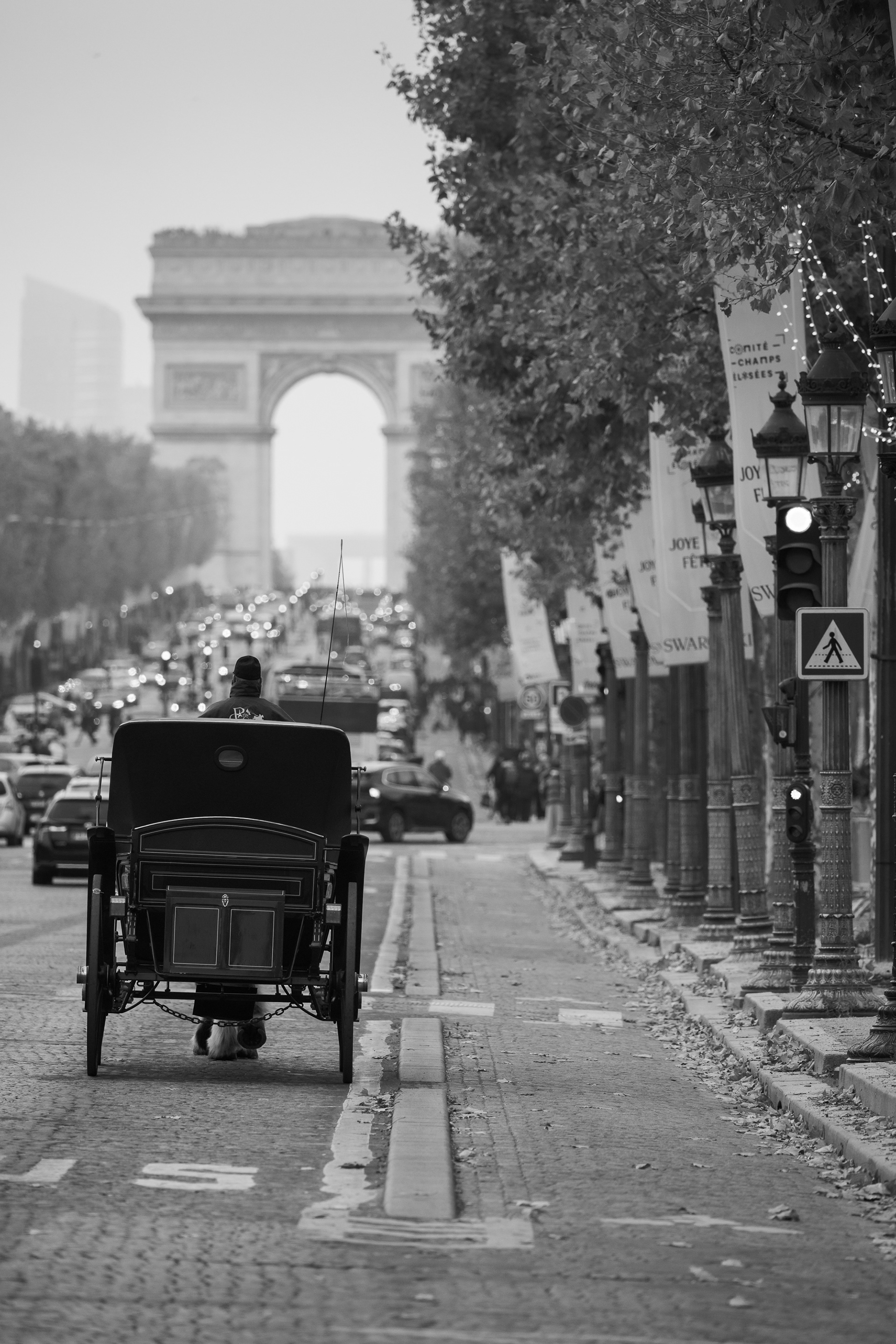 Traditional carriage riding along Champs-Élysées toward Arc de Triomphe