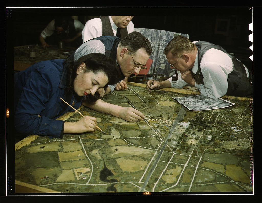 Camouflage class in New York University, where men and women are preparing for jobs in the Army or in industry, New York, N.Y. They make models from aerial photographs, re-photograph them, then work out a camouflage scheme and make a final photograph. Transfer from U.S. Office of War Information, 1944. Date : March 1943 Photographer: Marjory Collins