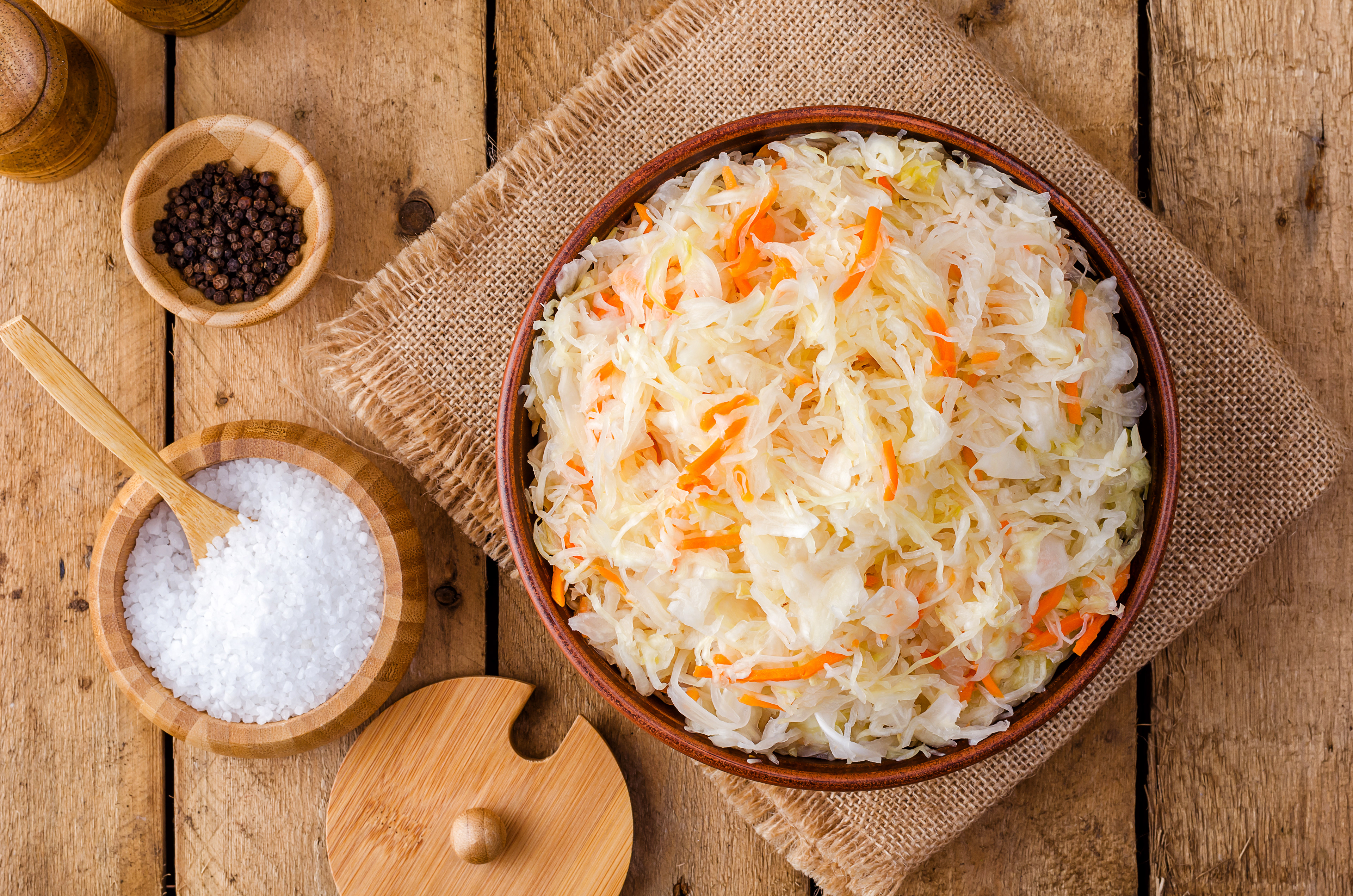 Можно квашеную. Sauerkraut – квашеная капуста.. Капуста квашеная на деревянном фоне. Капуста квашеная в глиняной миске. Капуста квашеная и деревянная ложка.