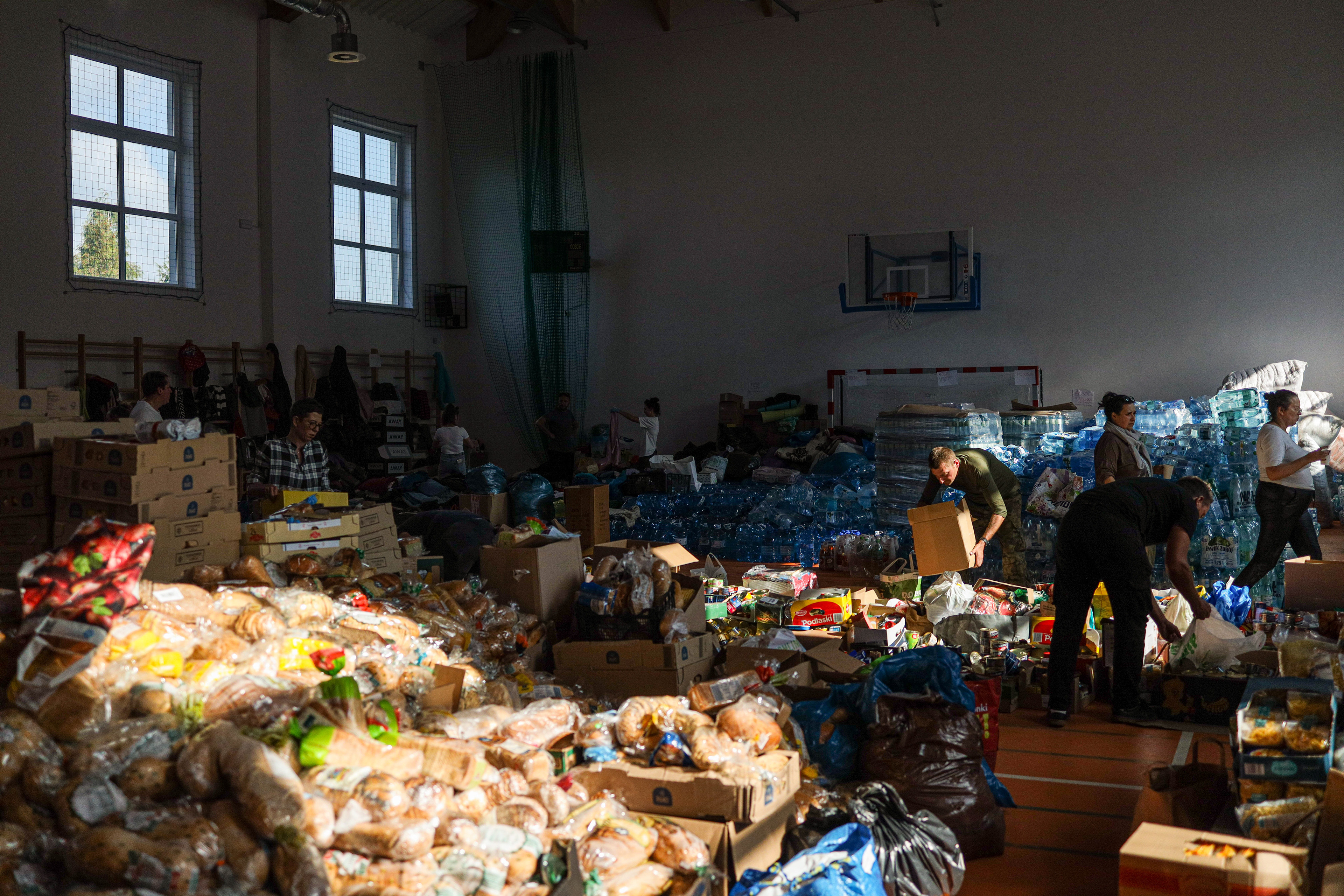 Stronie Śląskie, Poland. Inside a temporary aid center, volunteers sort donations as residents gather essential supplies after losing their homes in the flood.