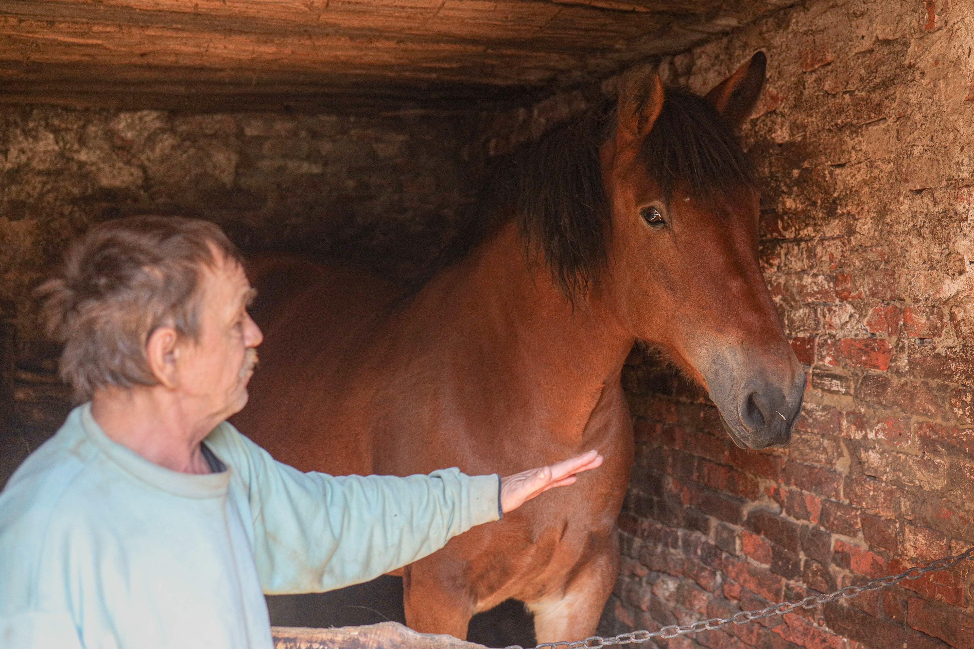 Bielice, Poland. Jan stands beside his horse, Basia, inside a building after the flood, which forced residents to protect their animals as water flooded homes and fields.