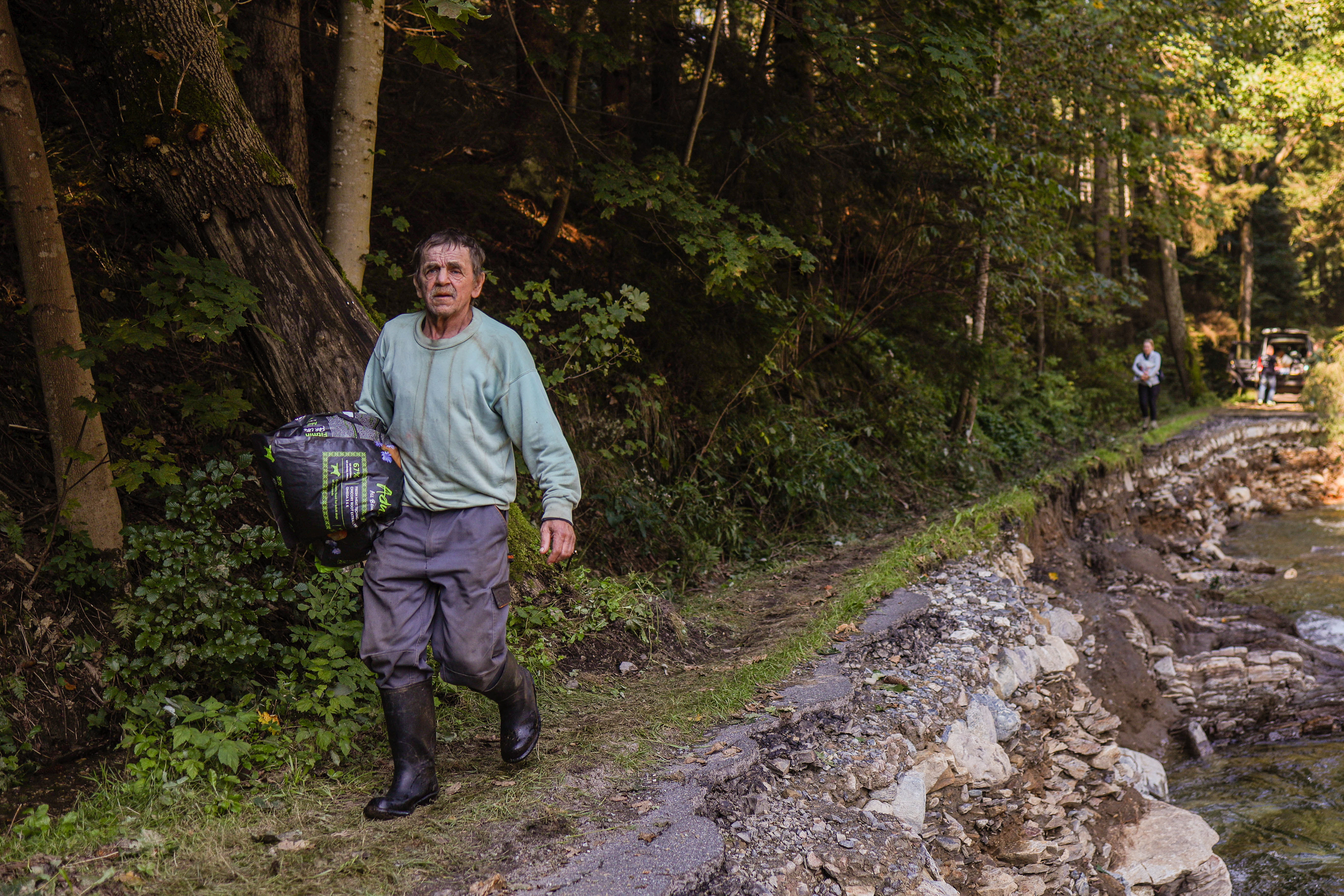 Bielice, Poland. Jan walks along a damaged road carrying belongings in a village cut off from the outside world after the flood destroyed roads and bridges.