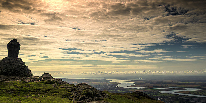 Panoramic image looking east towards the Firth of Forth from the summit of Dumyat hill in the Ochil Hills Scotland. In the far distance you can see the chimney or stack of Longannat Power Station and smoke from Grangemoth Petro Chemical Refinary