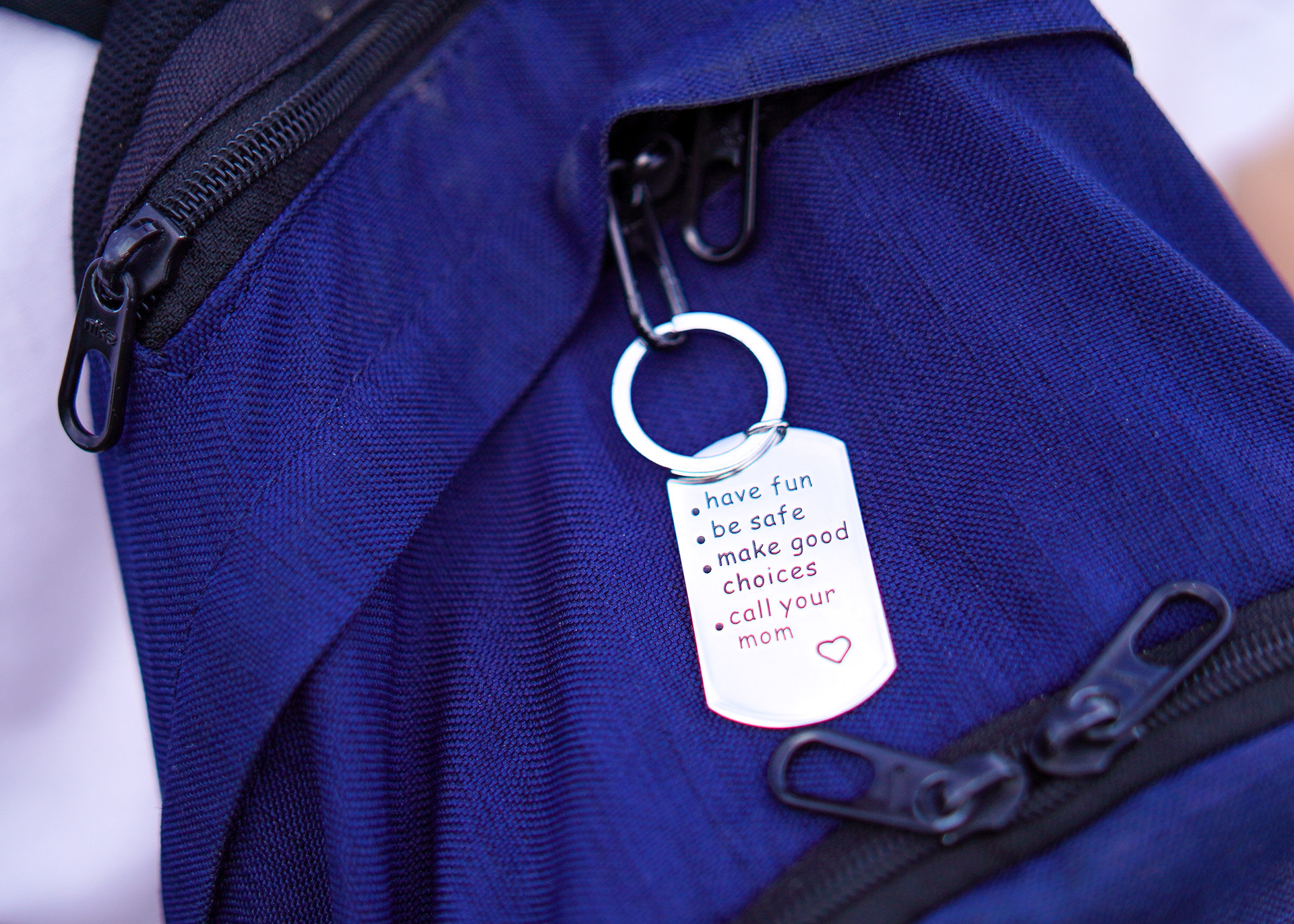 A travel bag tag hangs from a student-athlete's backpack.