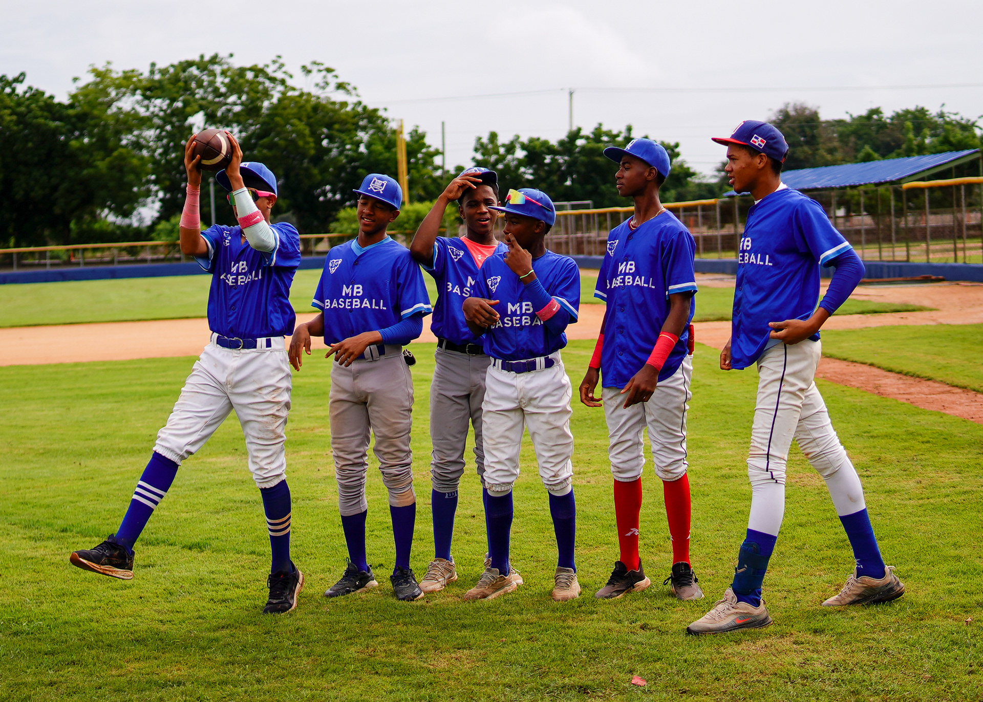 Academy players tossing an American football after rain postpones the day's game.