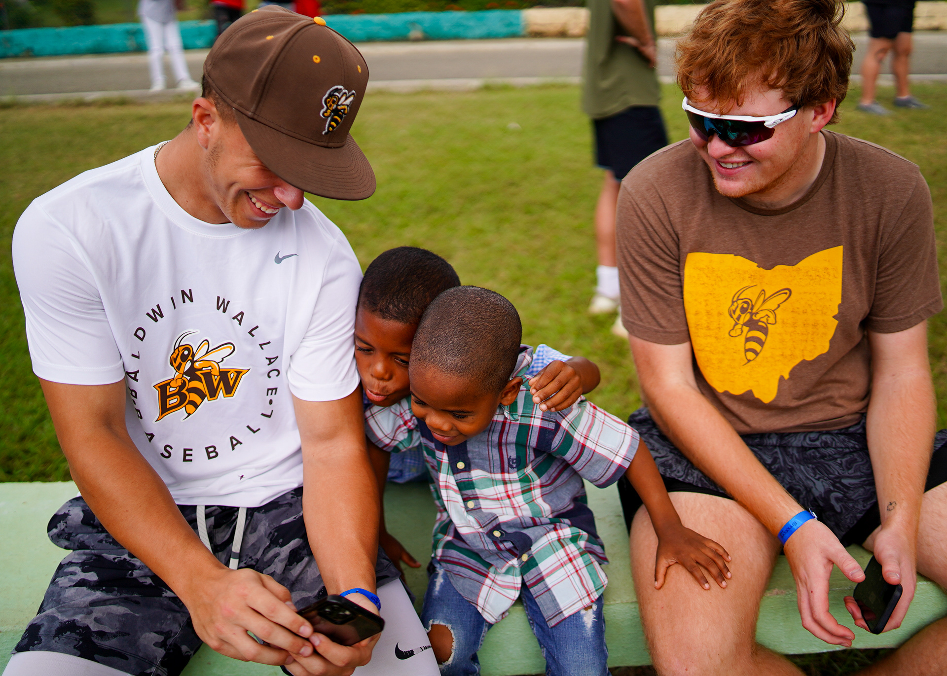 Students share smiles and laughter with children on a bench at the Orphanage.