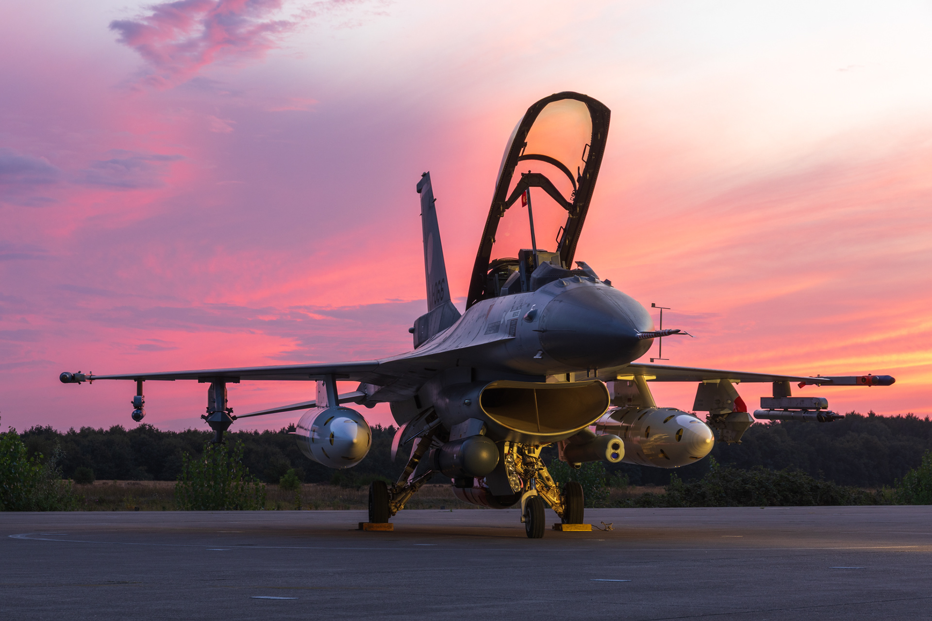 F-16 Fighting Falcon met openstaande canopy, tijdens een vuurrode zonsondergang