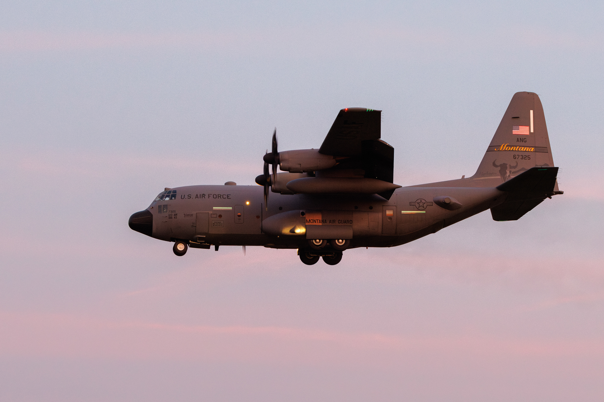 Een Amerikaanse C130 Hercules in de landing voor Vliegbasis Eindhoven in het laatste licht.
