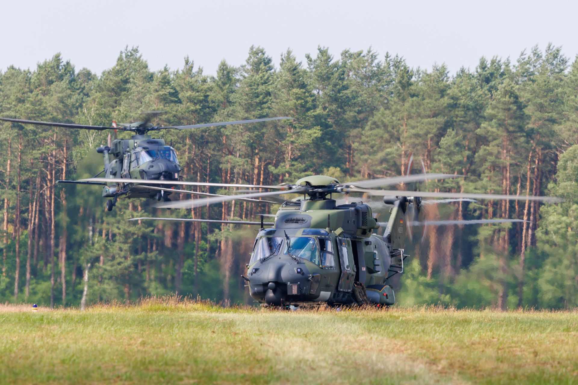 Twee NH90 helikopters landen op het vliegveld van Fassberg tijdens de Tag der Bundeswehr in 2024.