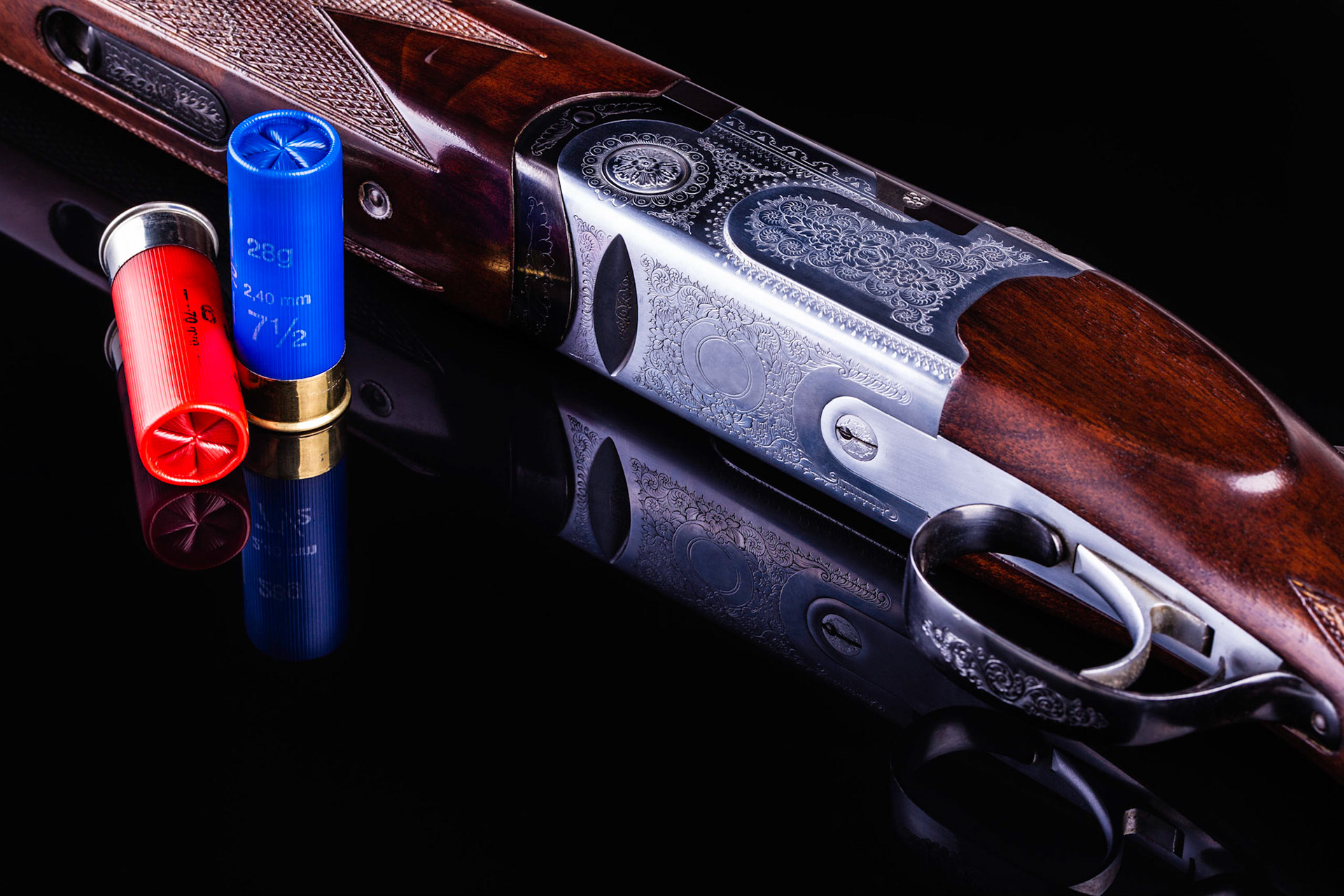detail of a classic vertical over-under double barreled shotgun over a dark surface