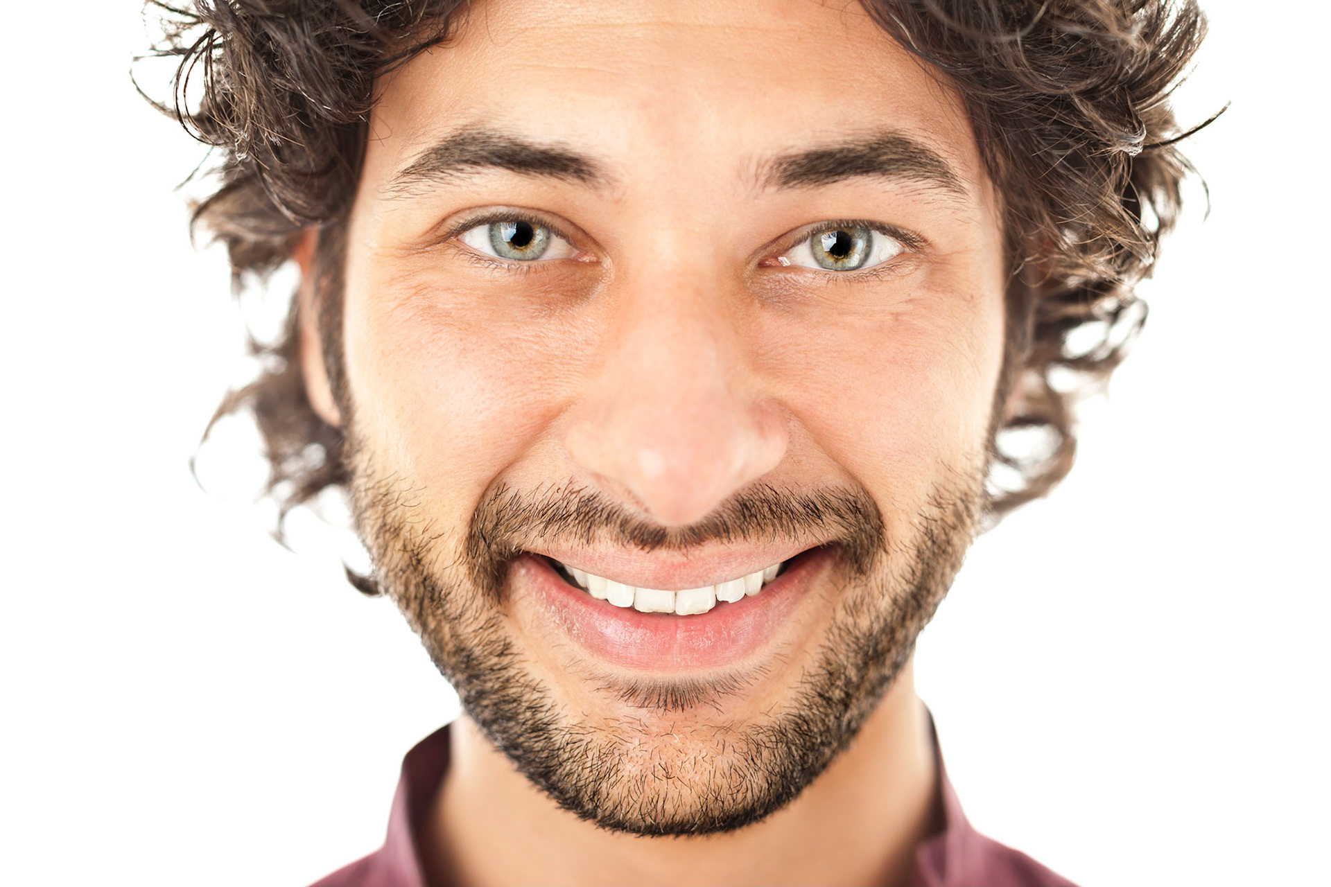 Handsome man with green eyes posing over a white background