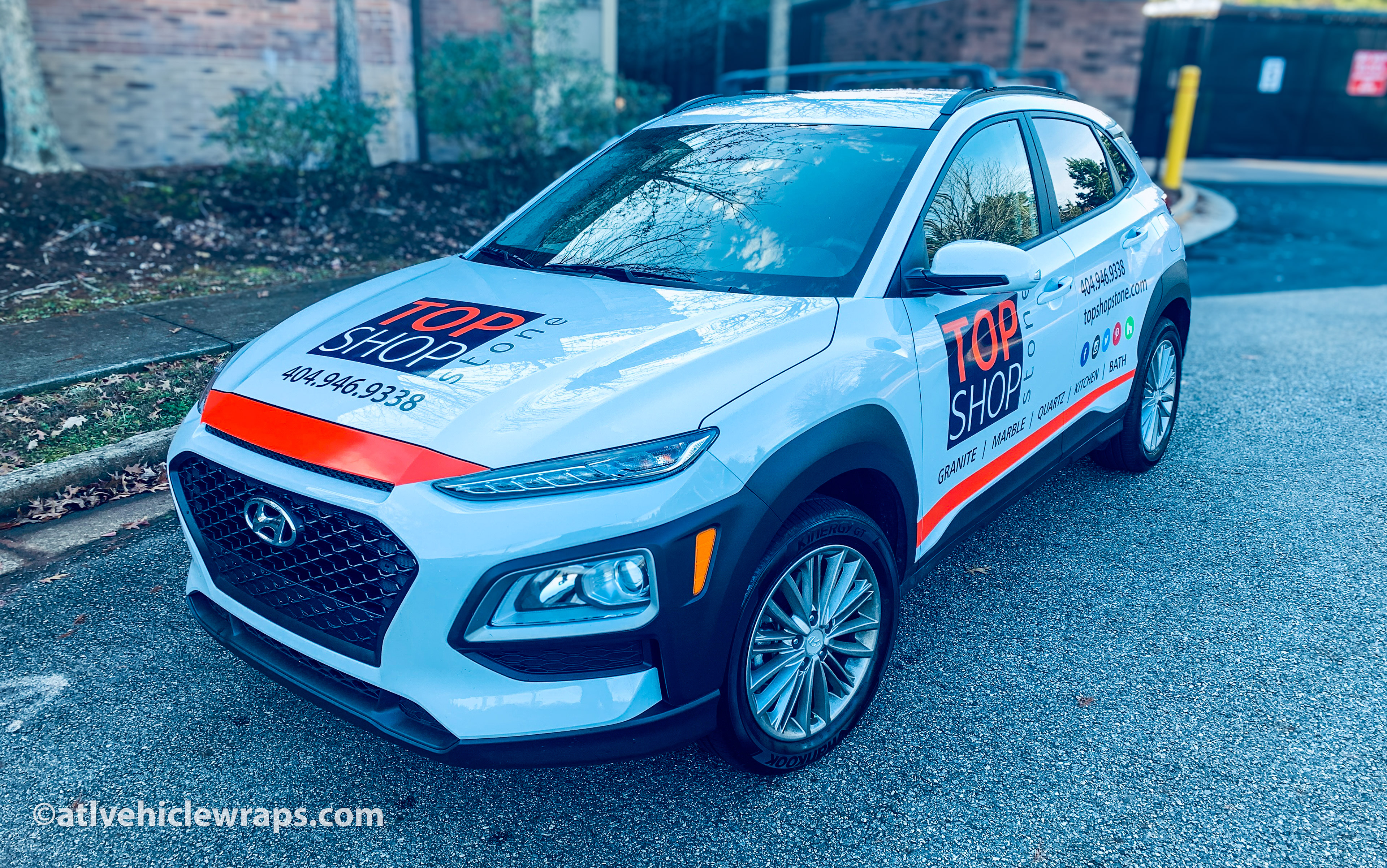 Close-up of the stone surfaces company's logo and crisp vinyl decals on the Hyundai Kona.