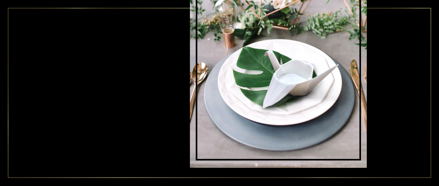 black and gold premium branding with white fine bone china orgami crane in an elegant table setting with a monsterra leaf