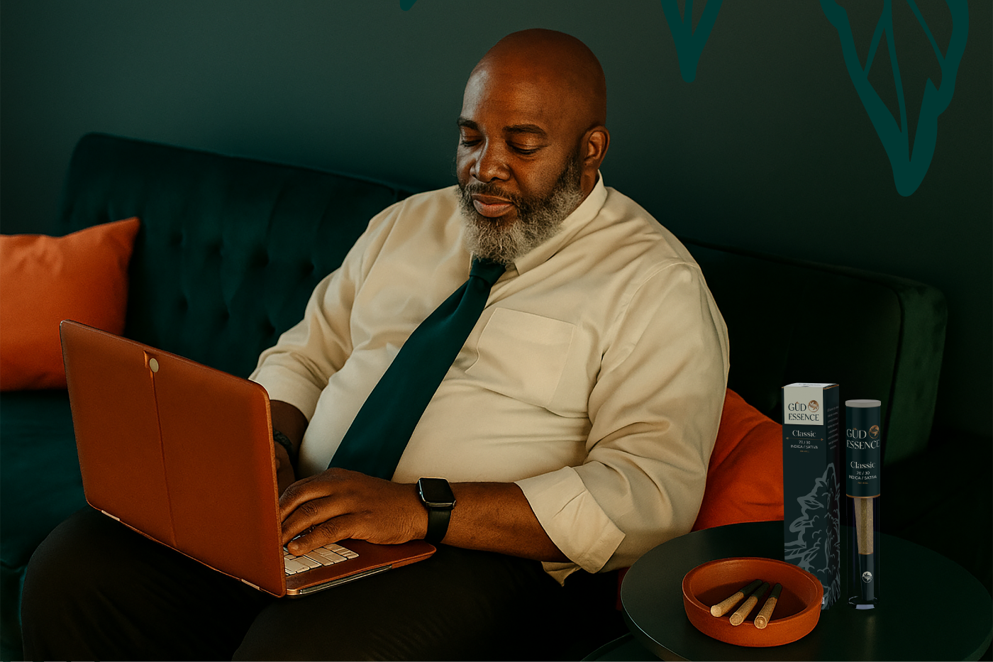 black corporate man seated with his laptop with GUD Essence products vape on his side
